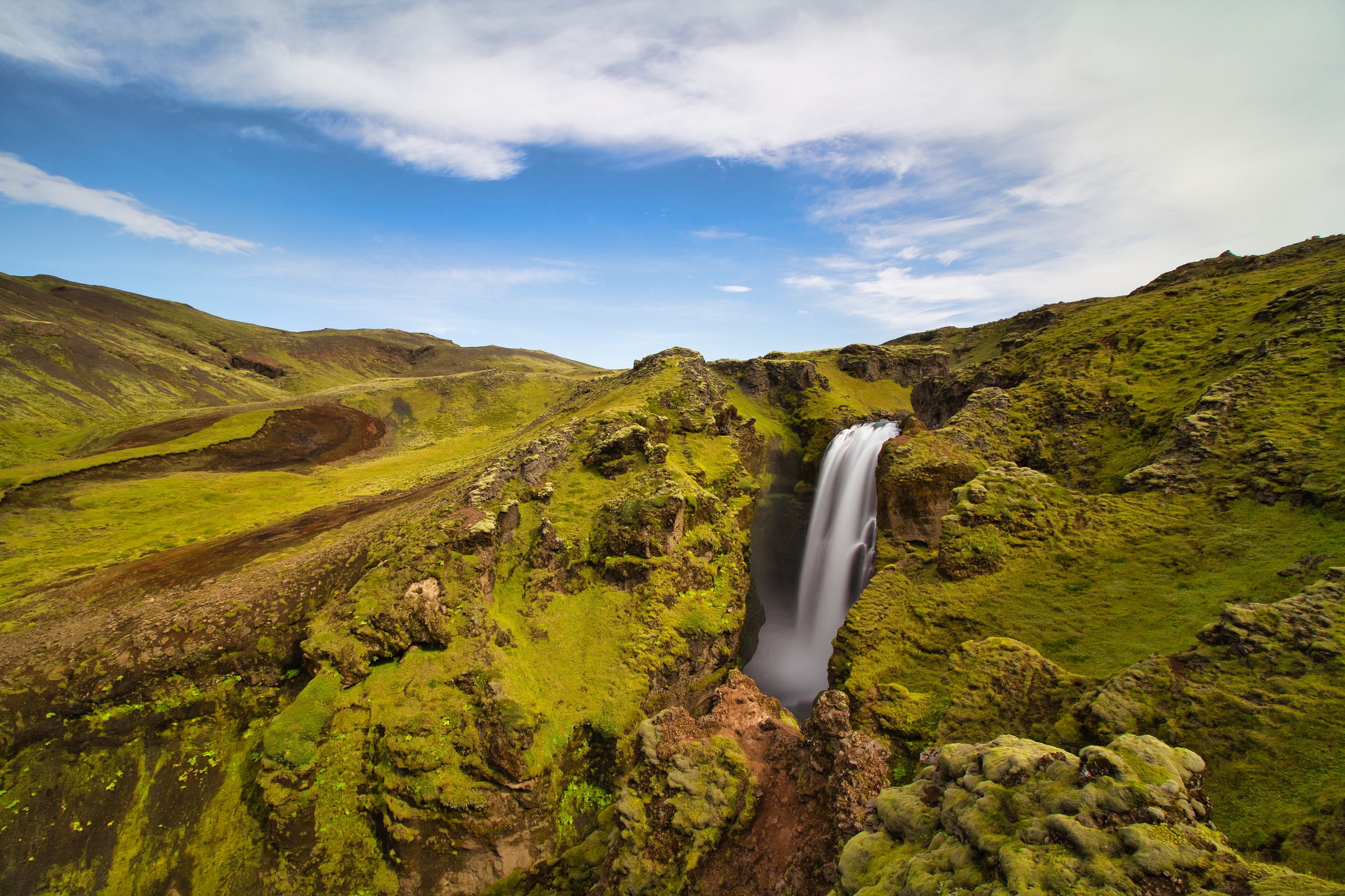 Waterfall in Iceland's green landscape HD Wallpaper