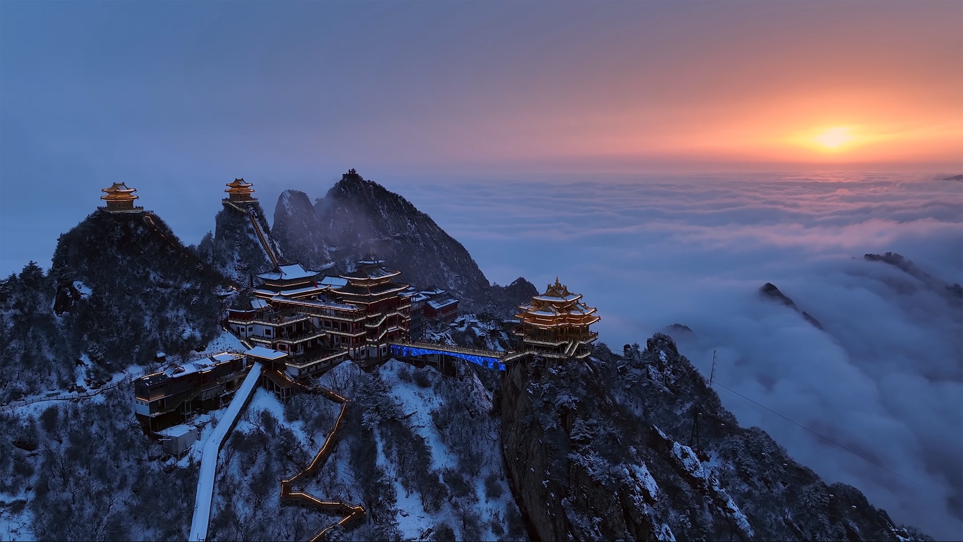 Temple on snowy mountains above clouds at sunset in China HD Wallpaper