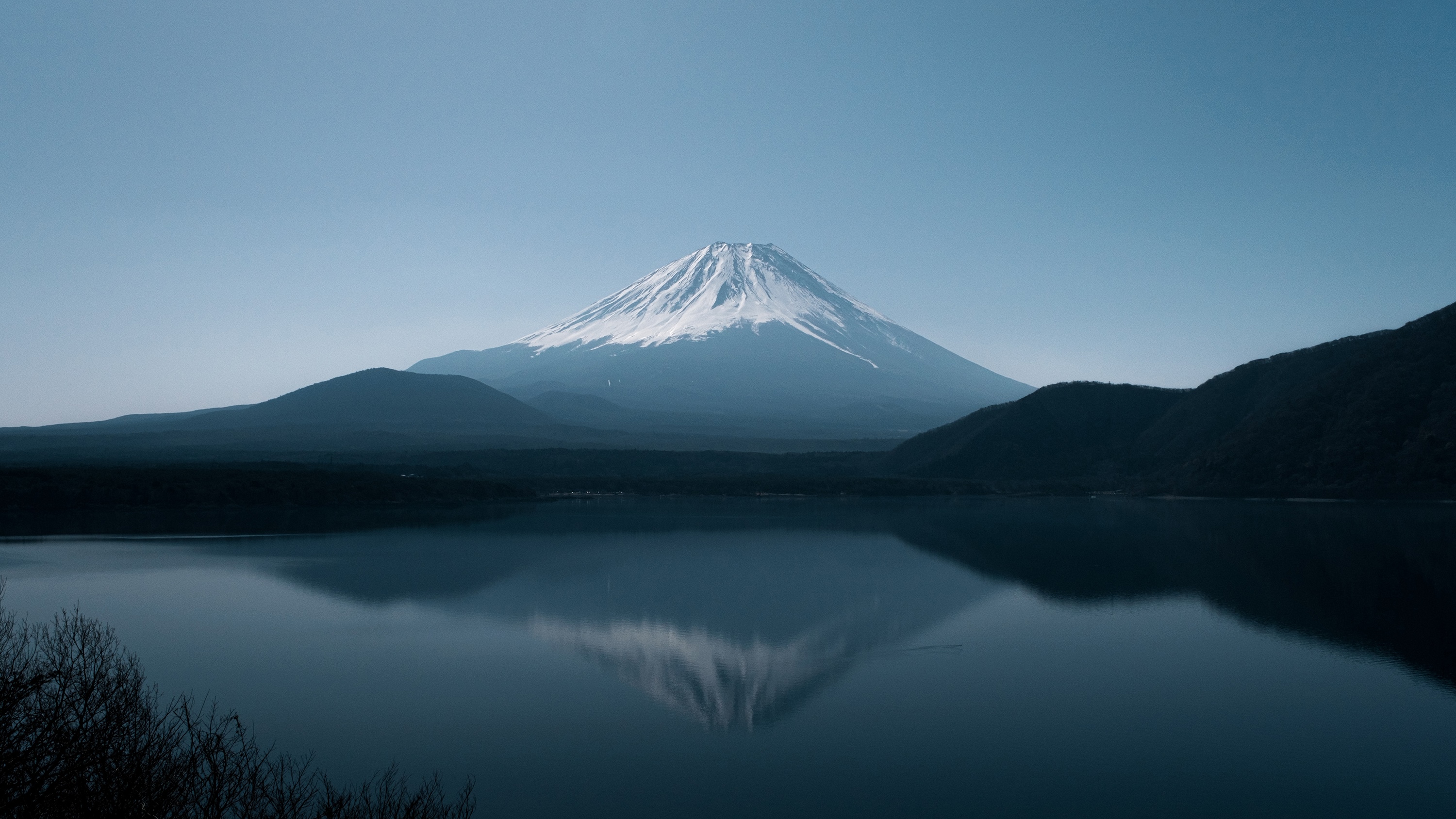 Mount Fuji reflected in a calm lake under a clear sky HD Wallpaper