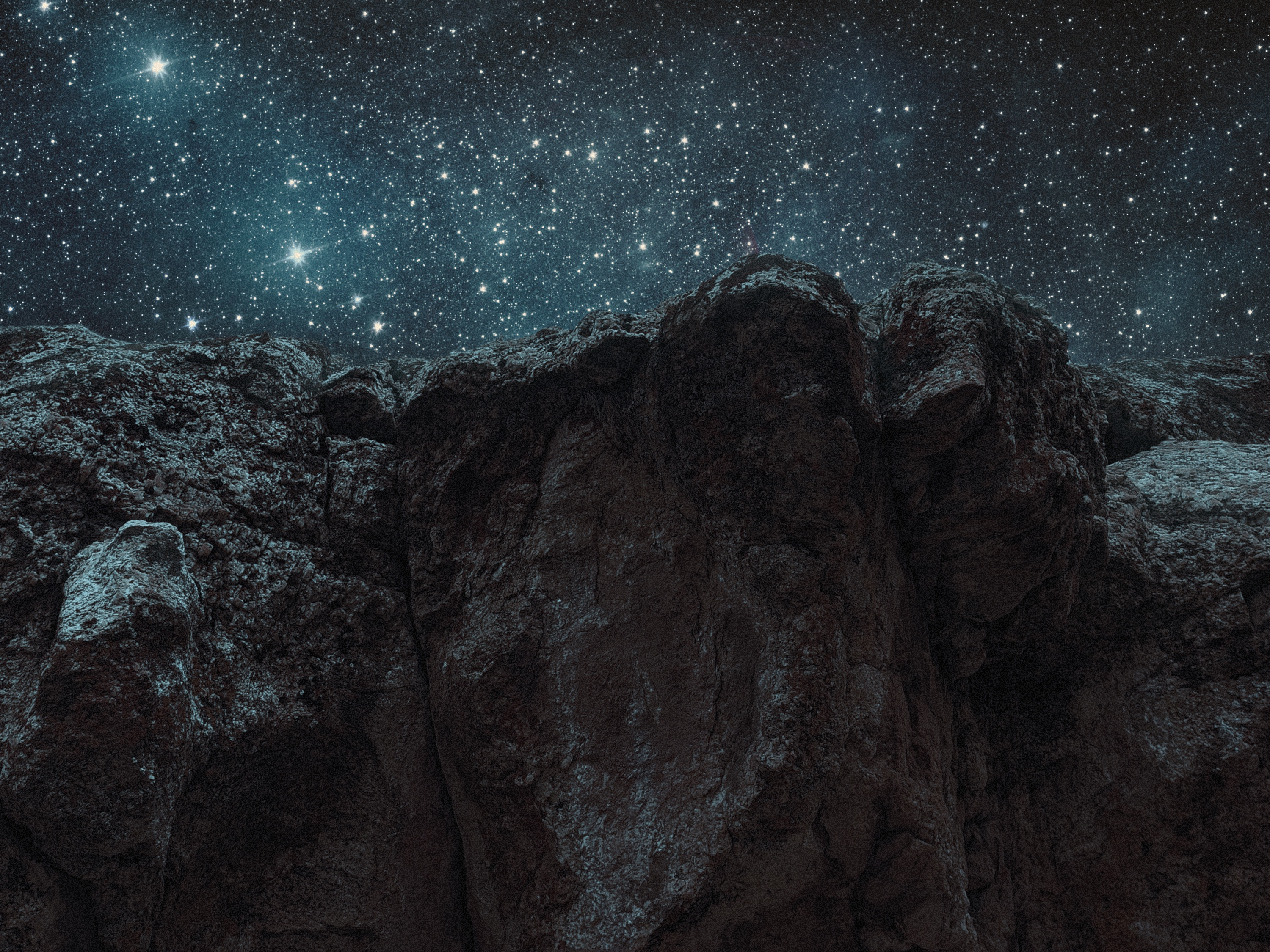 Rocky terrain under a starry night sky HD Wallpaper