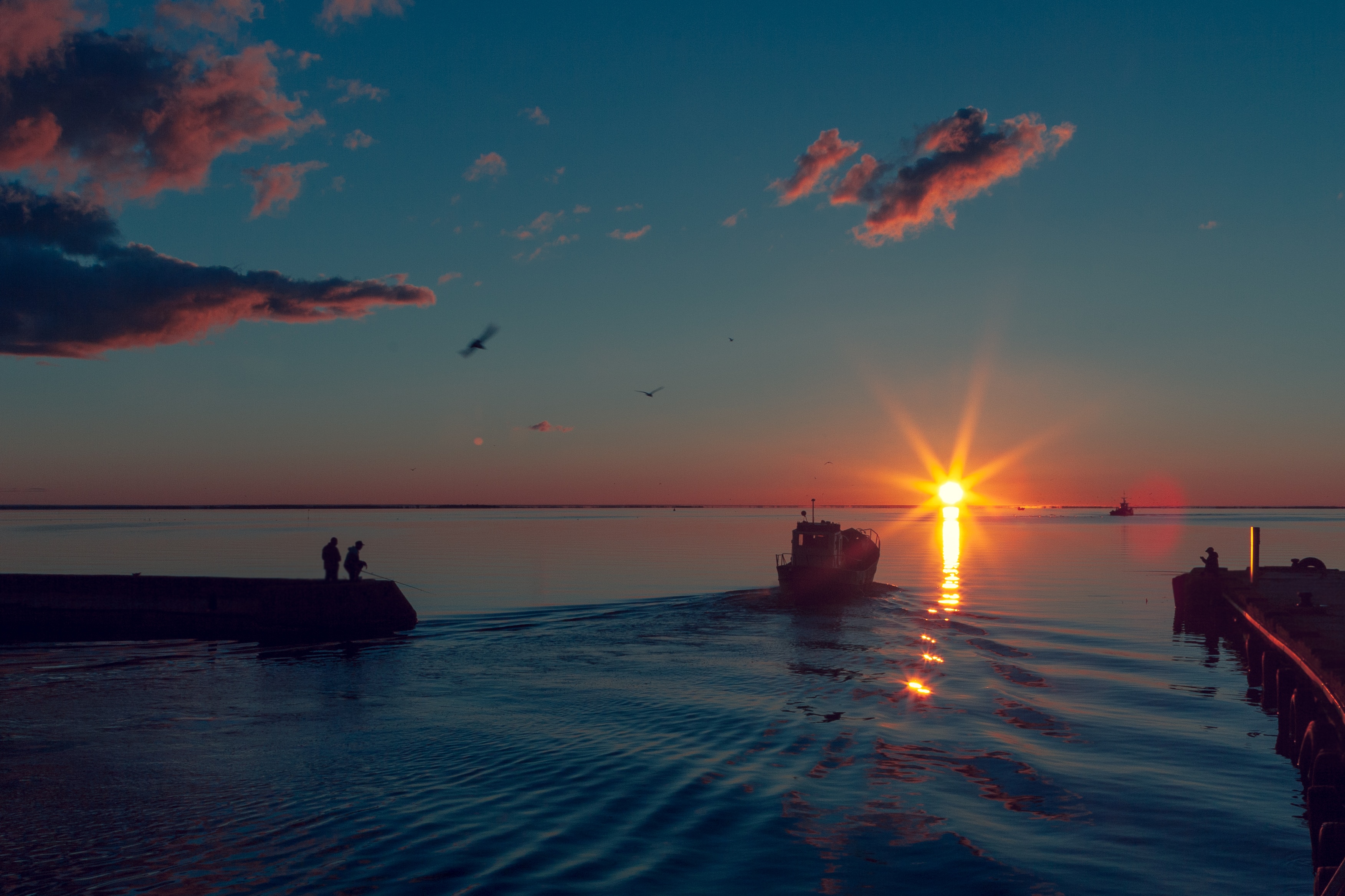 Boat sailing on the sea at sunset with clouds HD Wallpaper