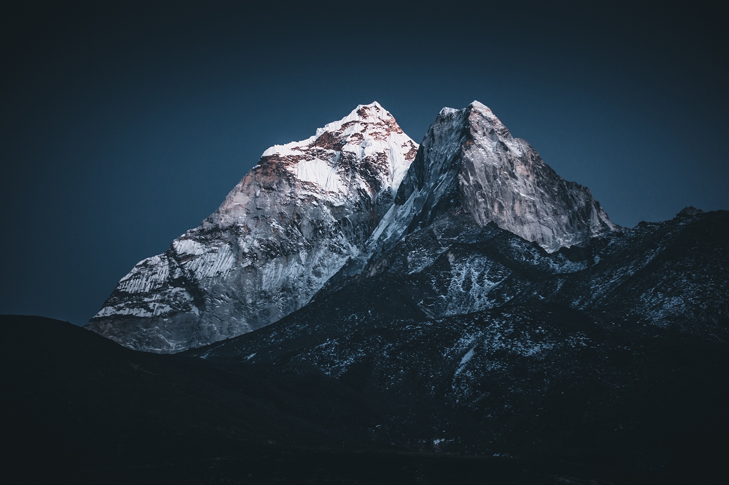 Snow-capped mountains under a dark blue sky HD Wallpaper