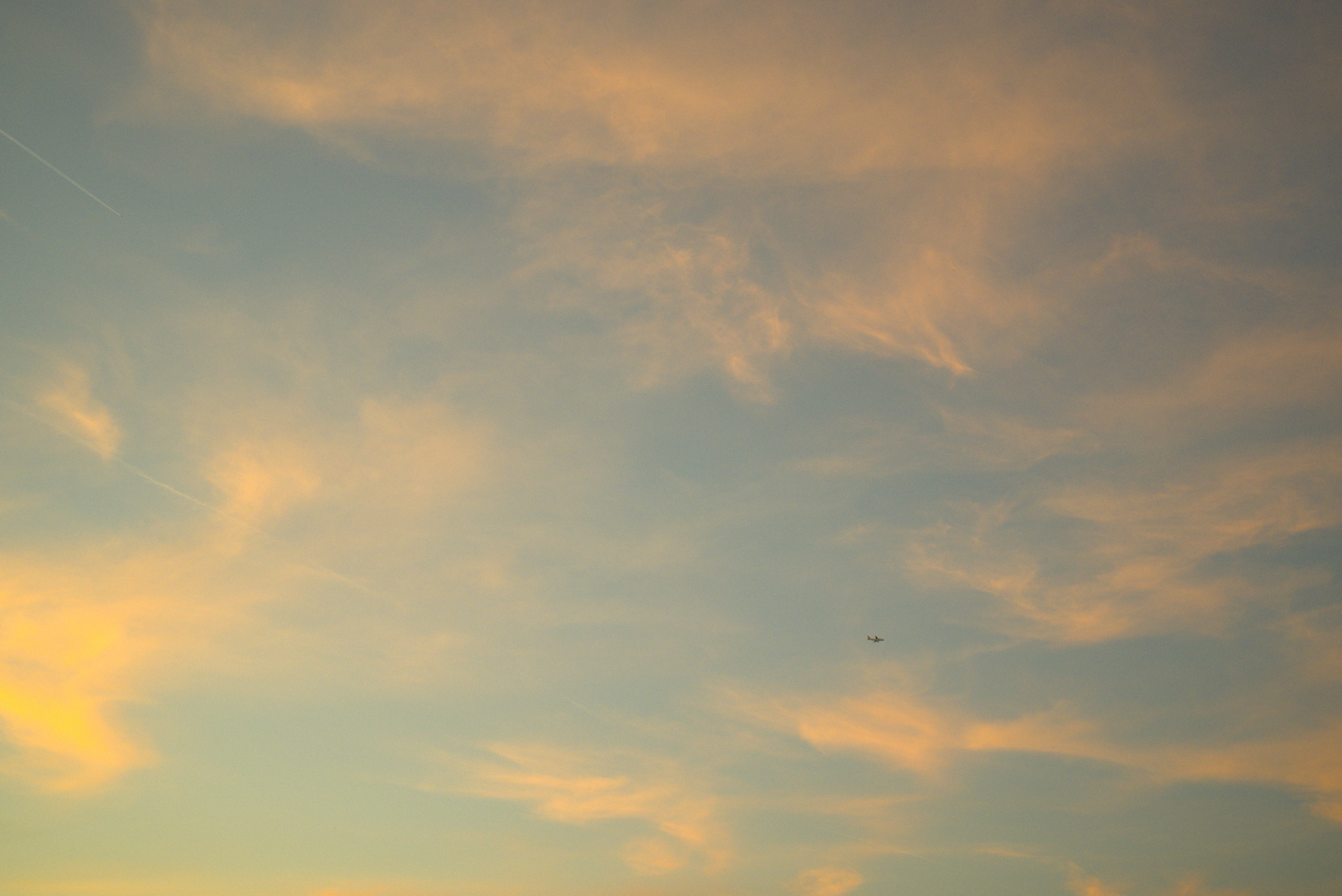 Airplane flying in a cloudy sky at sunset HD Wallpaper