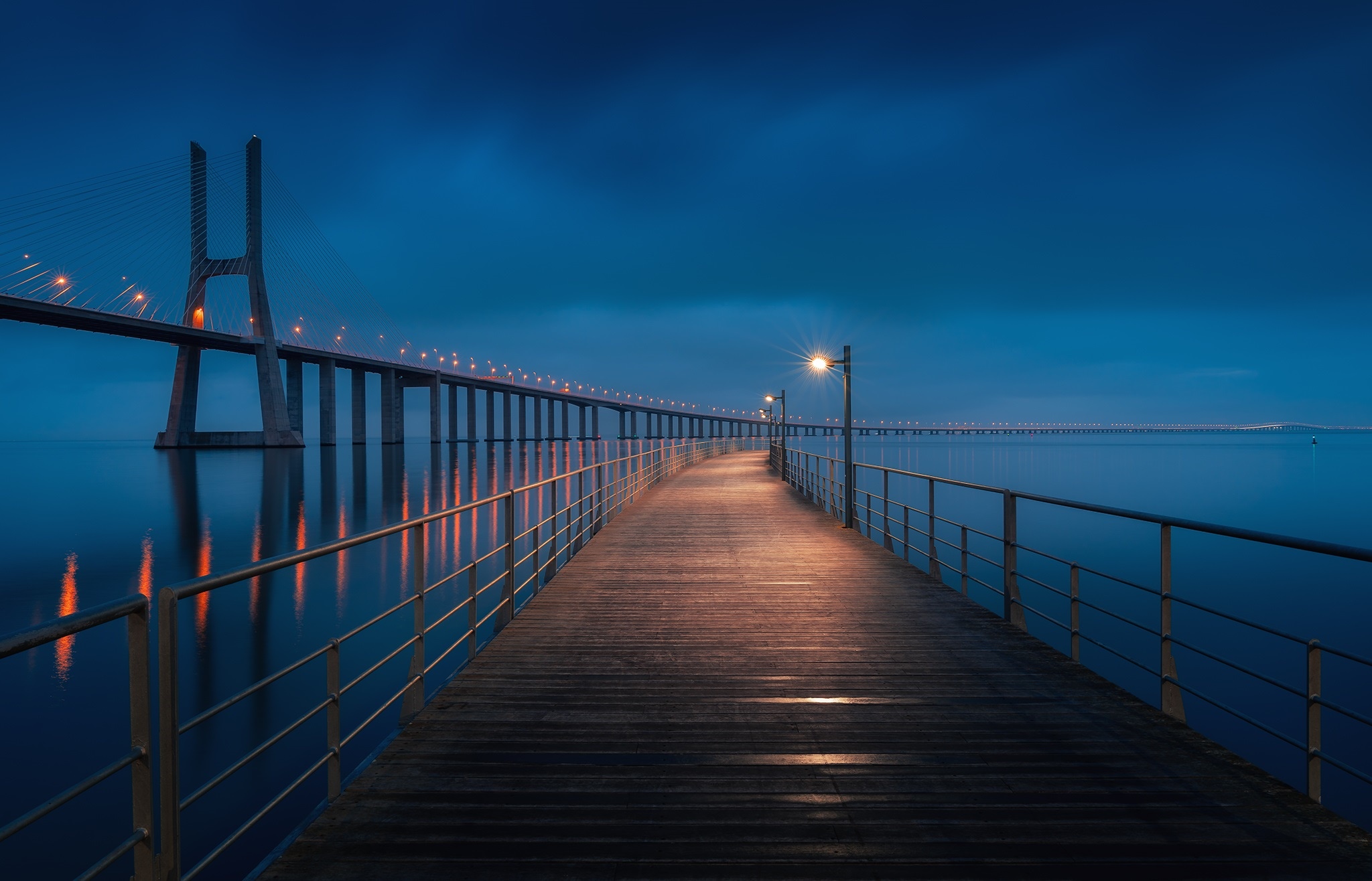 Vasco da Gama Bridge at night with a pier HD Wallpaper