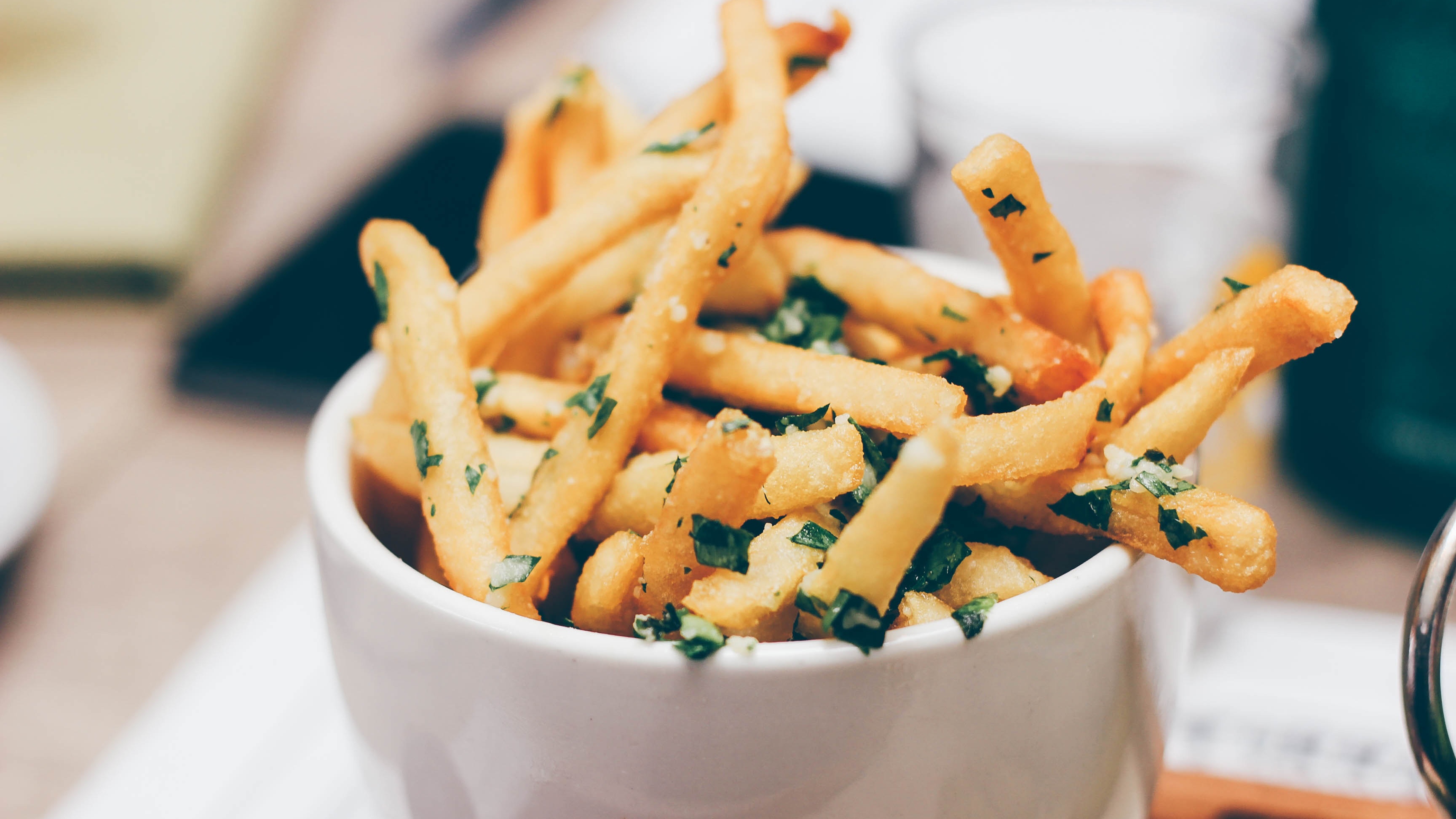 French fries with herbs in a white bowl HD Wallpaper