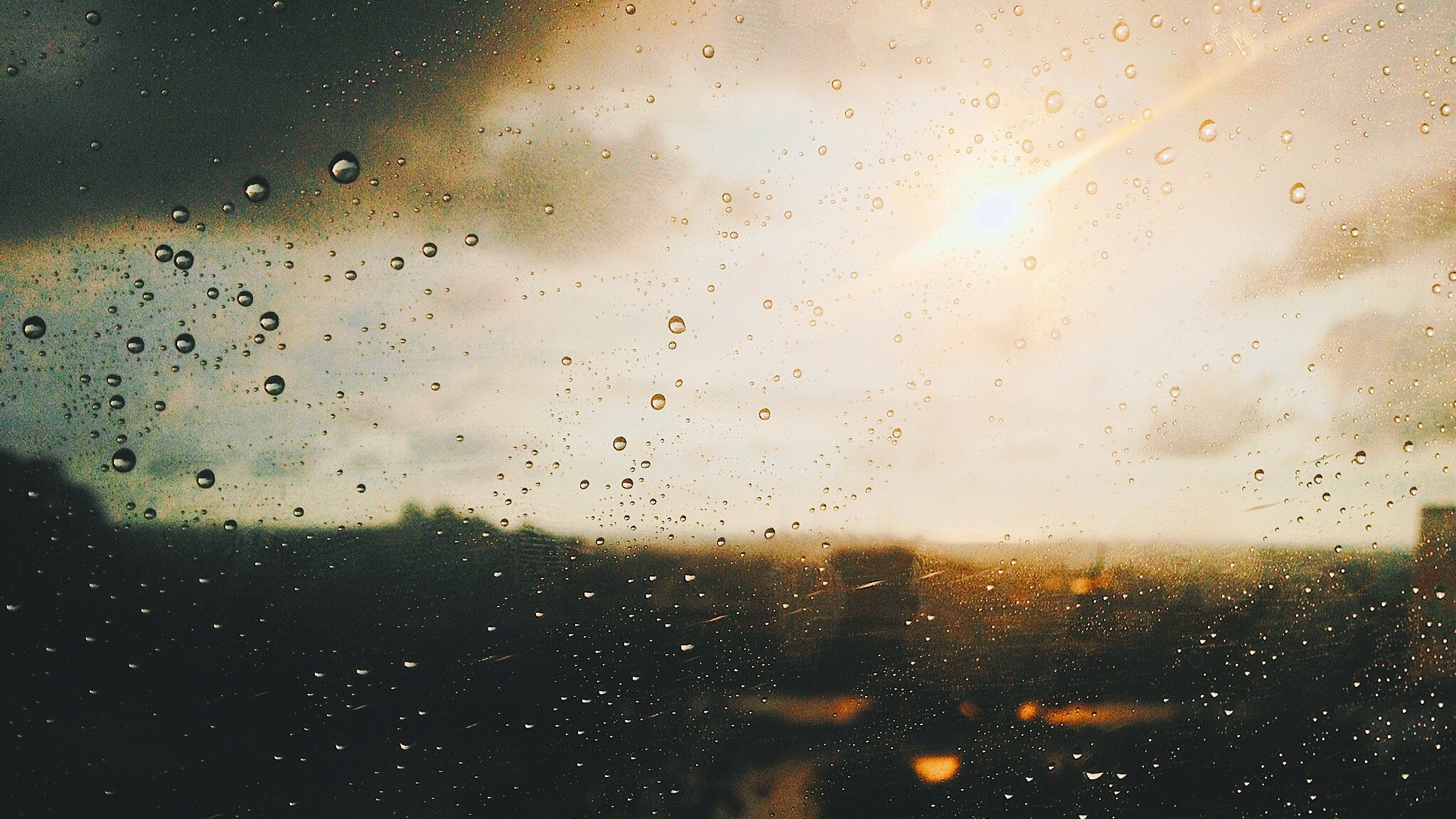 Raindrops on a window with sun and clouds HD Wallpaper