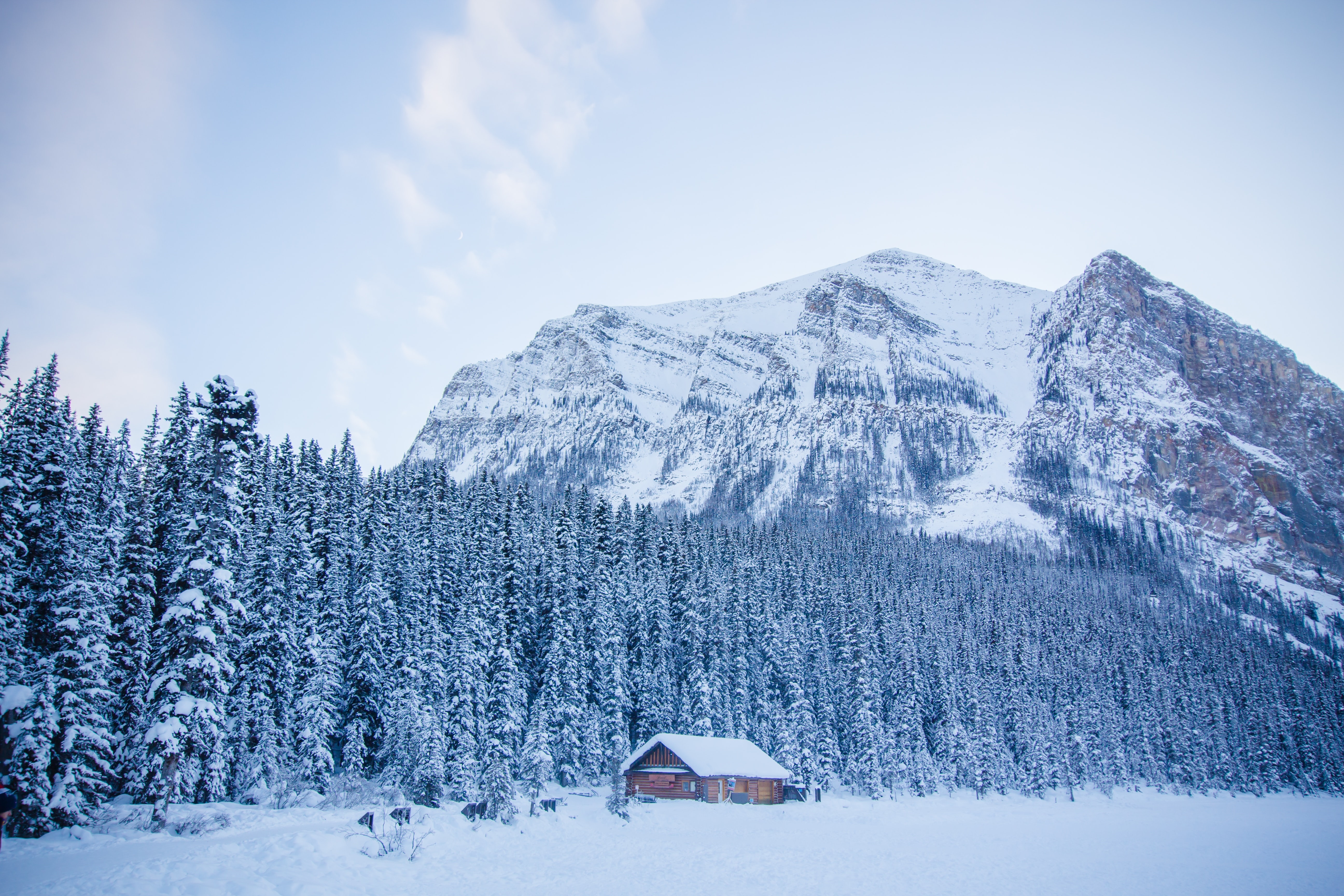 4K Lake Louise winter landscape with snow-covered mountains and cabin HD Wallpaper