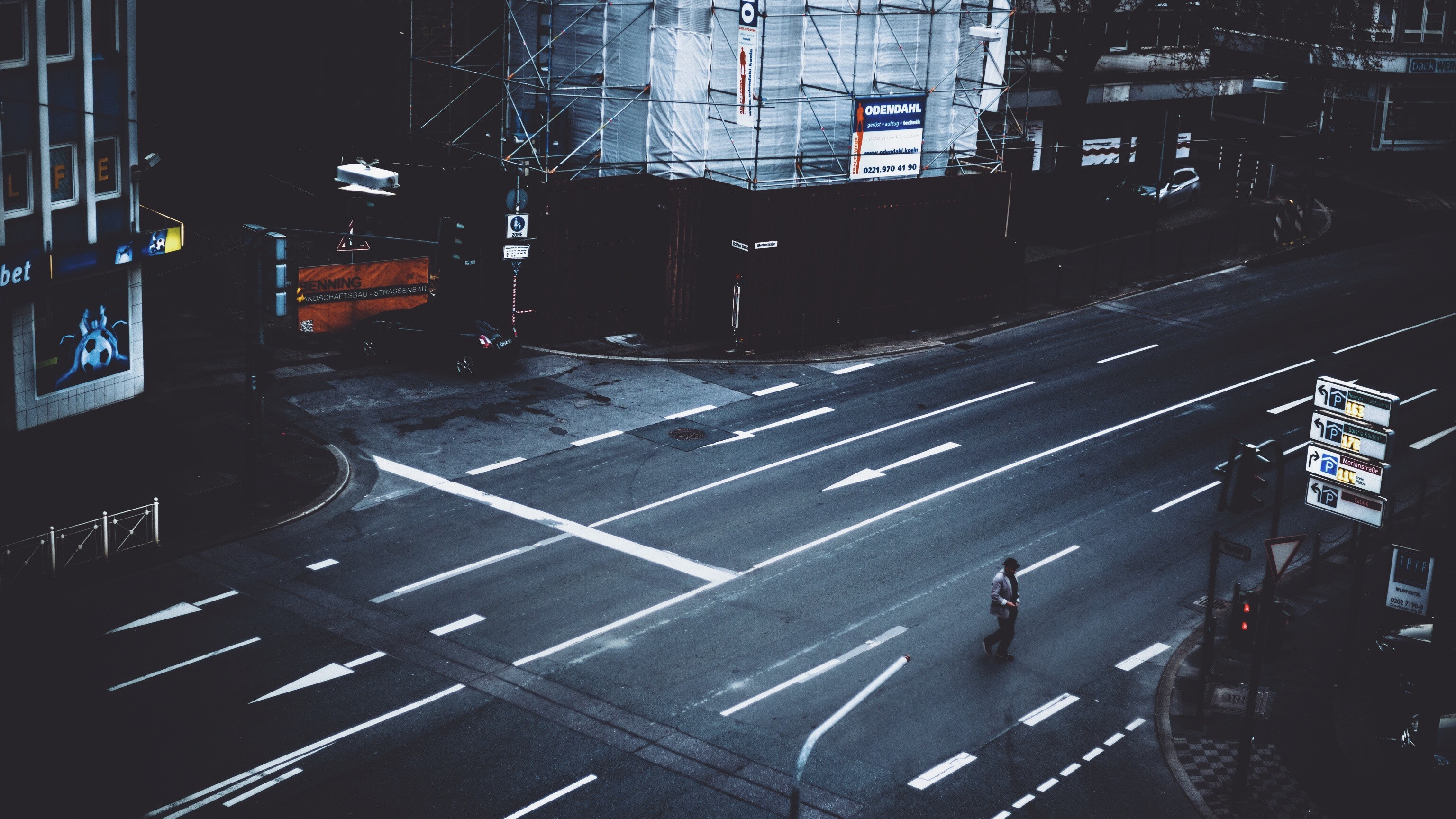 Man crosses a dark, empty street at night HD Wallpaper
