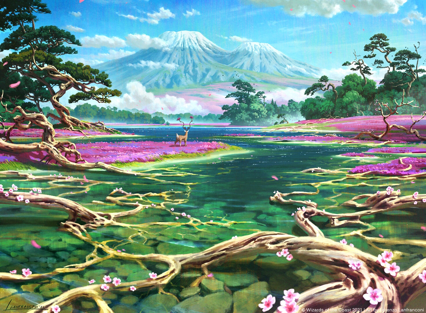A deer stands in a field of flowers by a river with mountains in the background. HD Wallpaper
