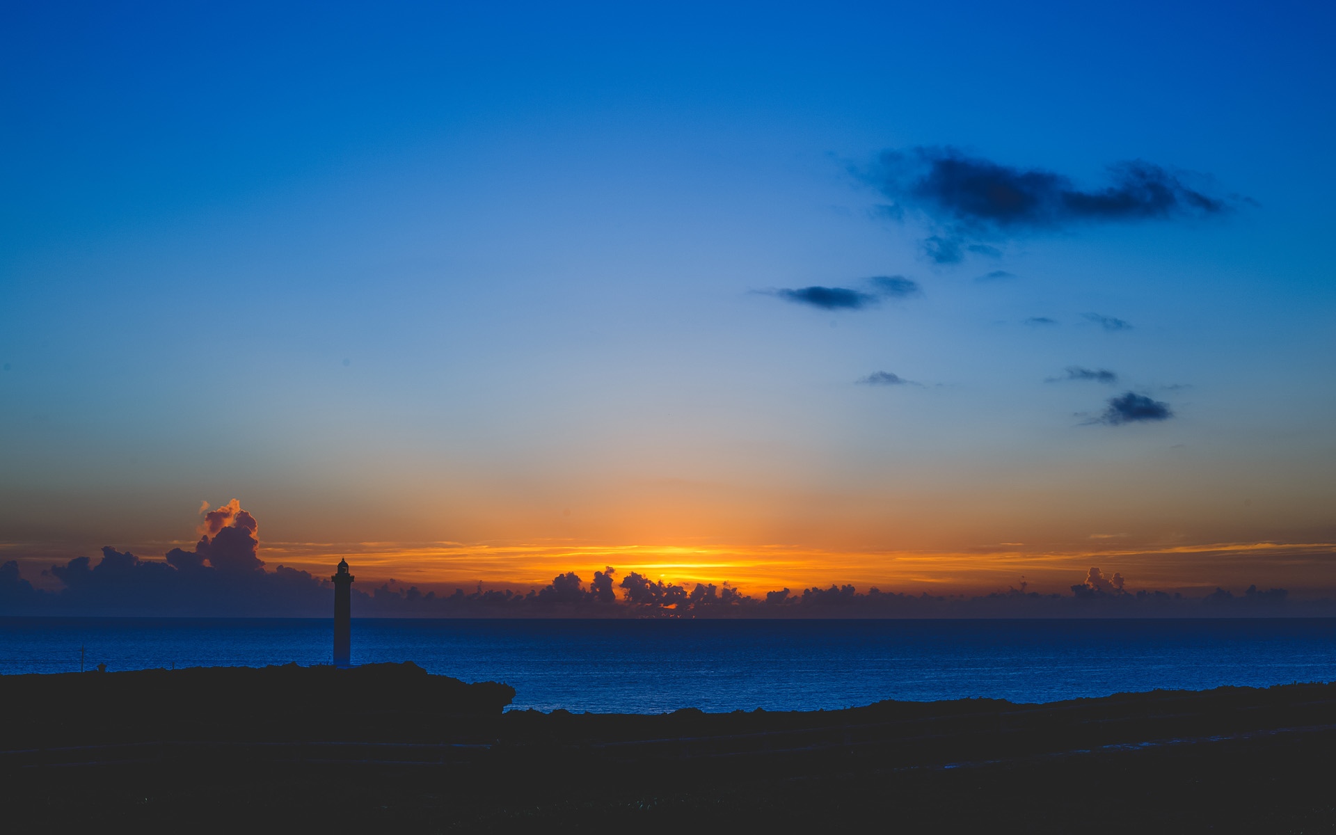 Lighthouse at sunset over the ocean HD Wallpaper