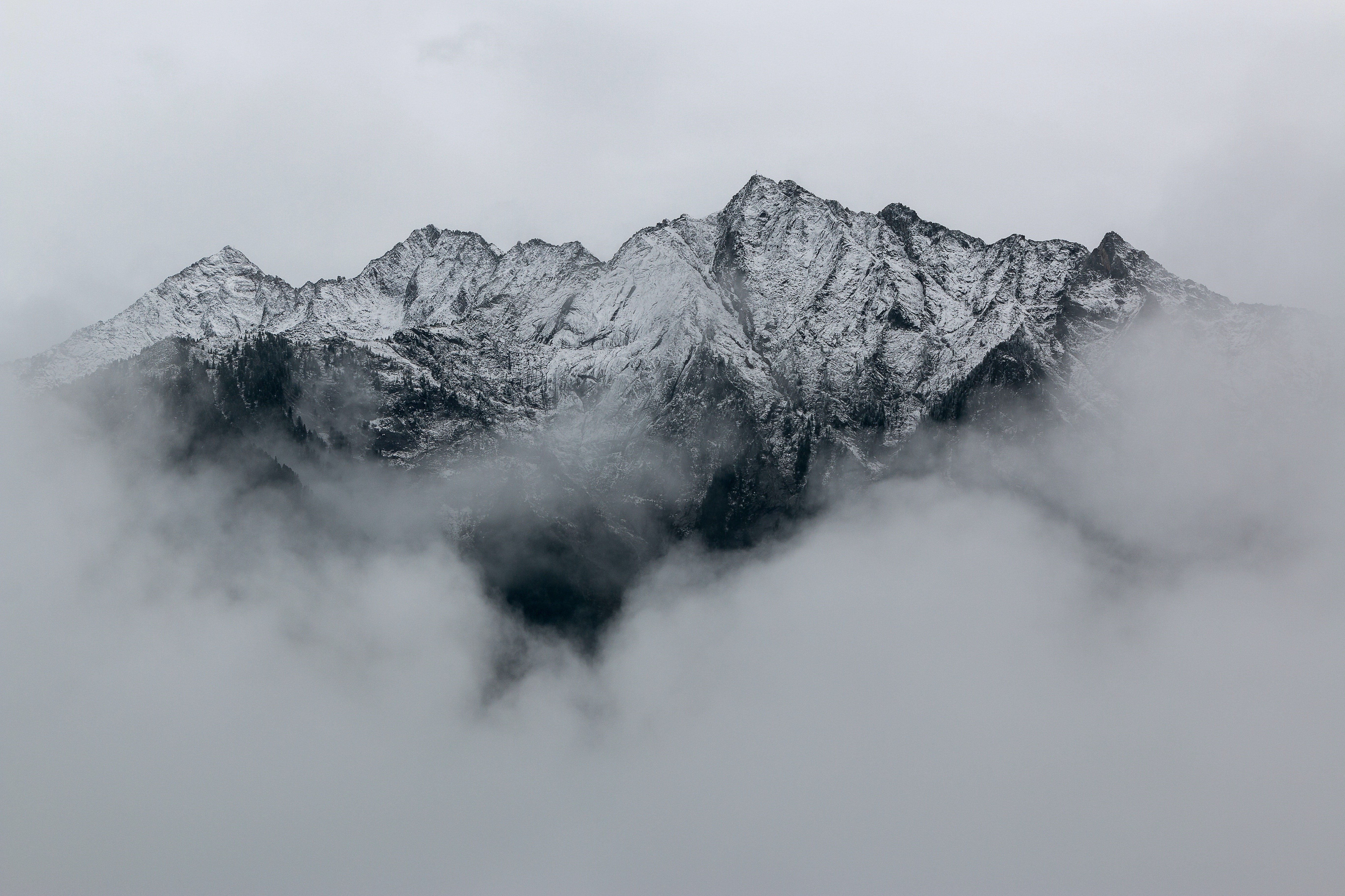 Snow-capped mountains shrouded in clouds HD Wallpaper
