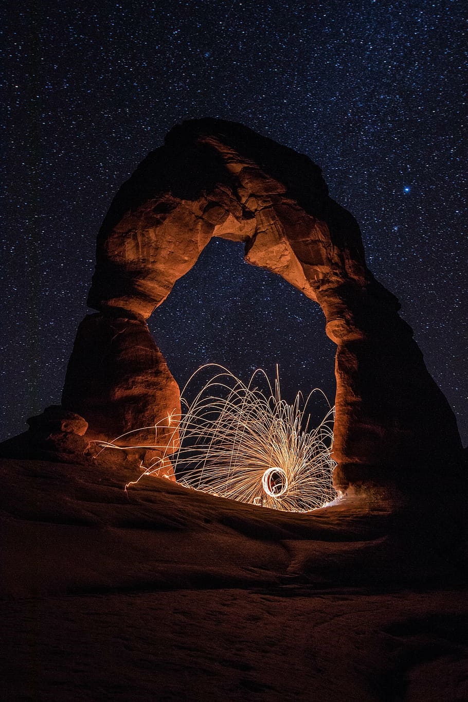 Steel Wool Sparks Under Delicate Arch at Night HD Phone Wallpaper