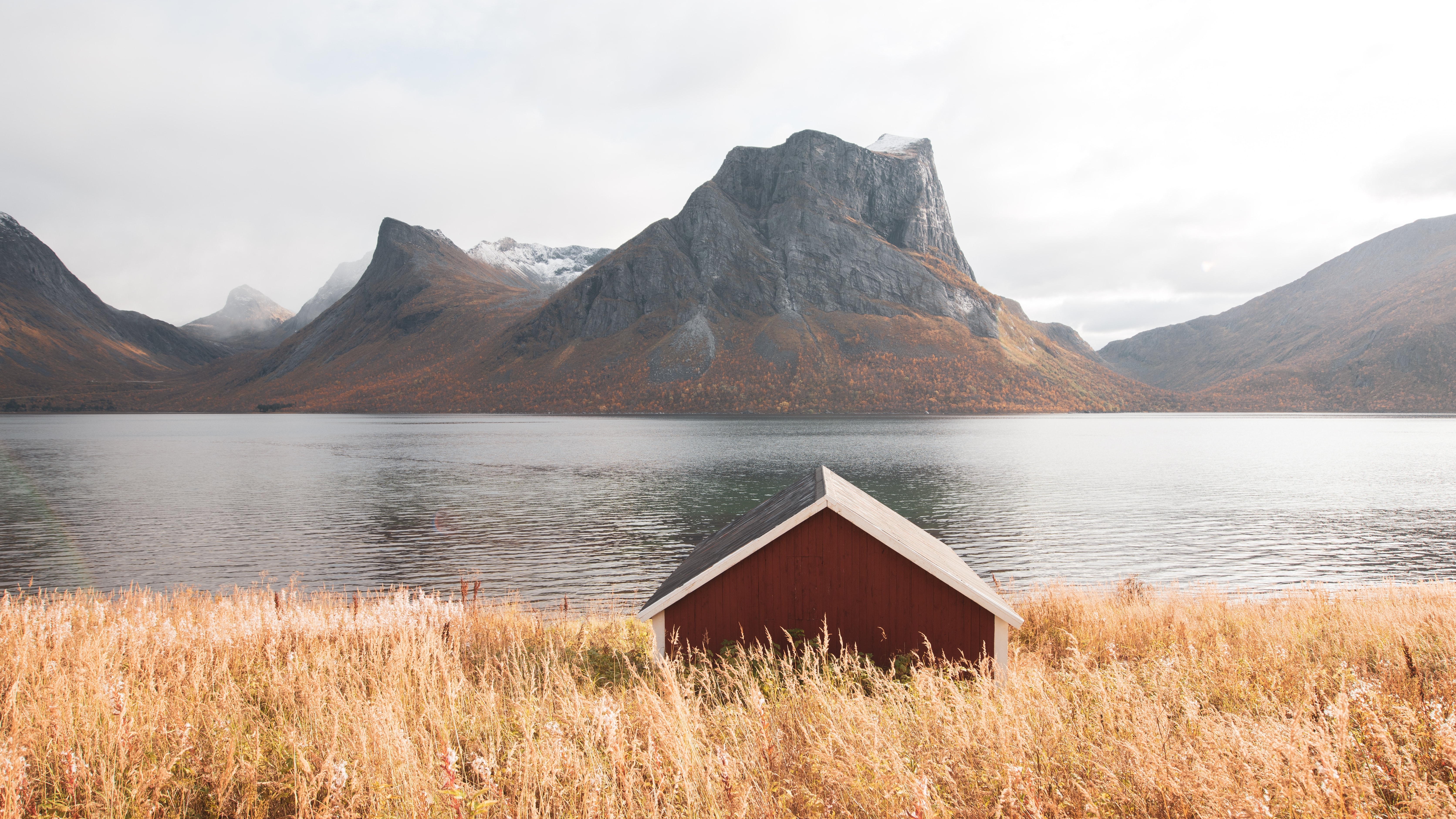 Red cabin by a lake with mountains in Norway HD Wallpaper