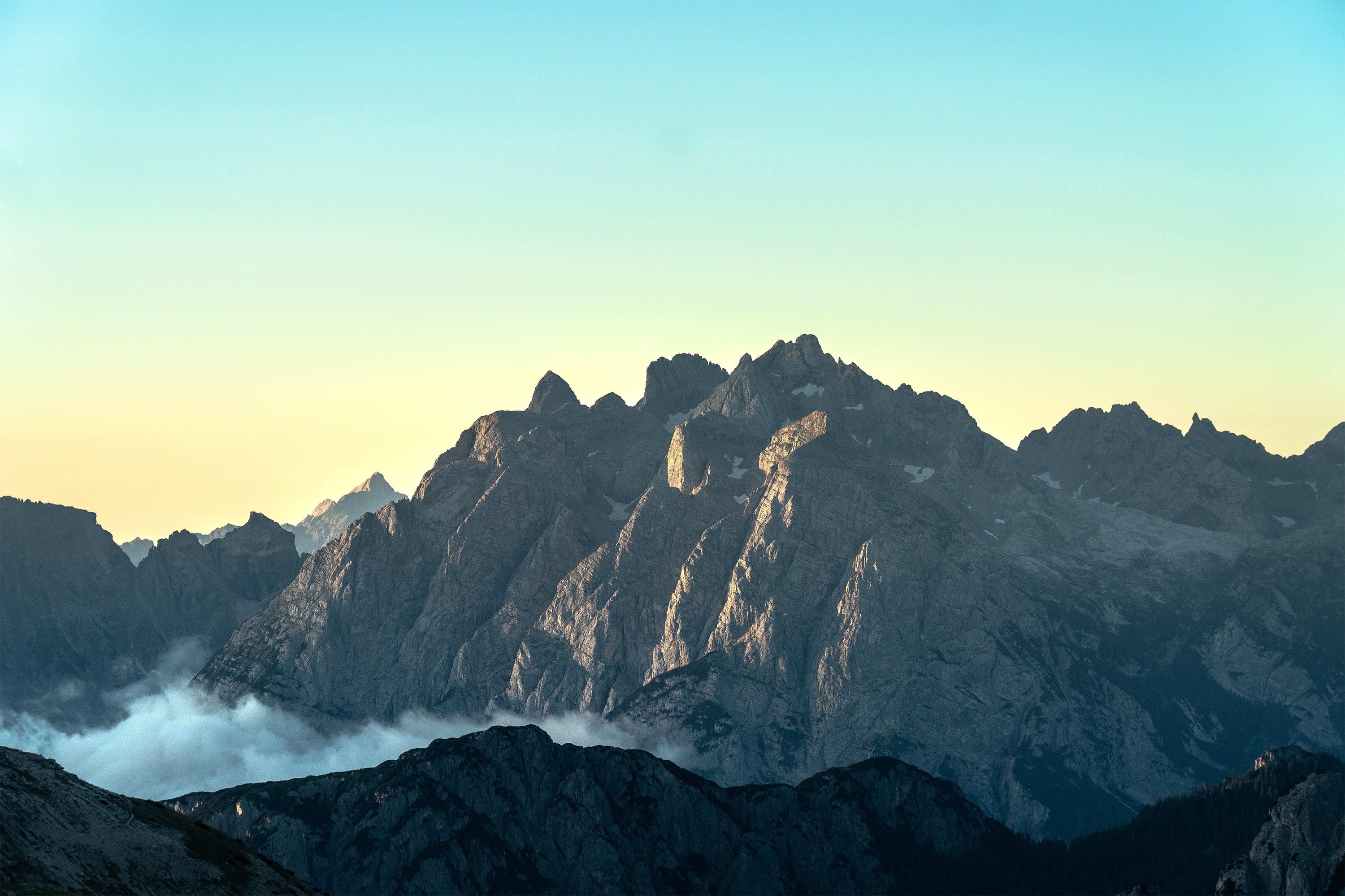 Jagged mountain peaks under a gradient sky HD Wallpaper