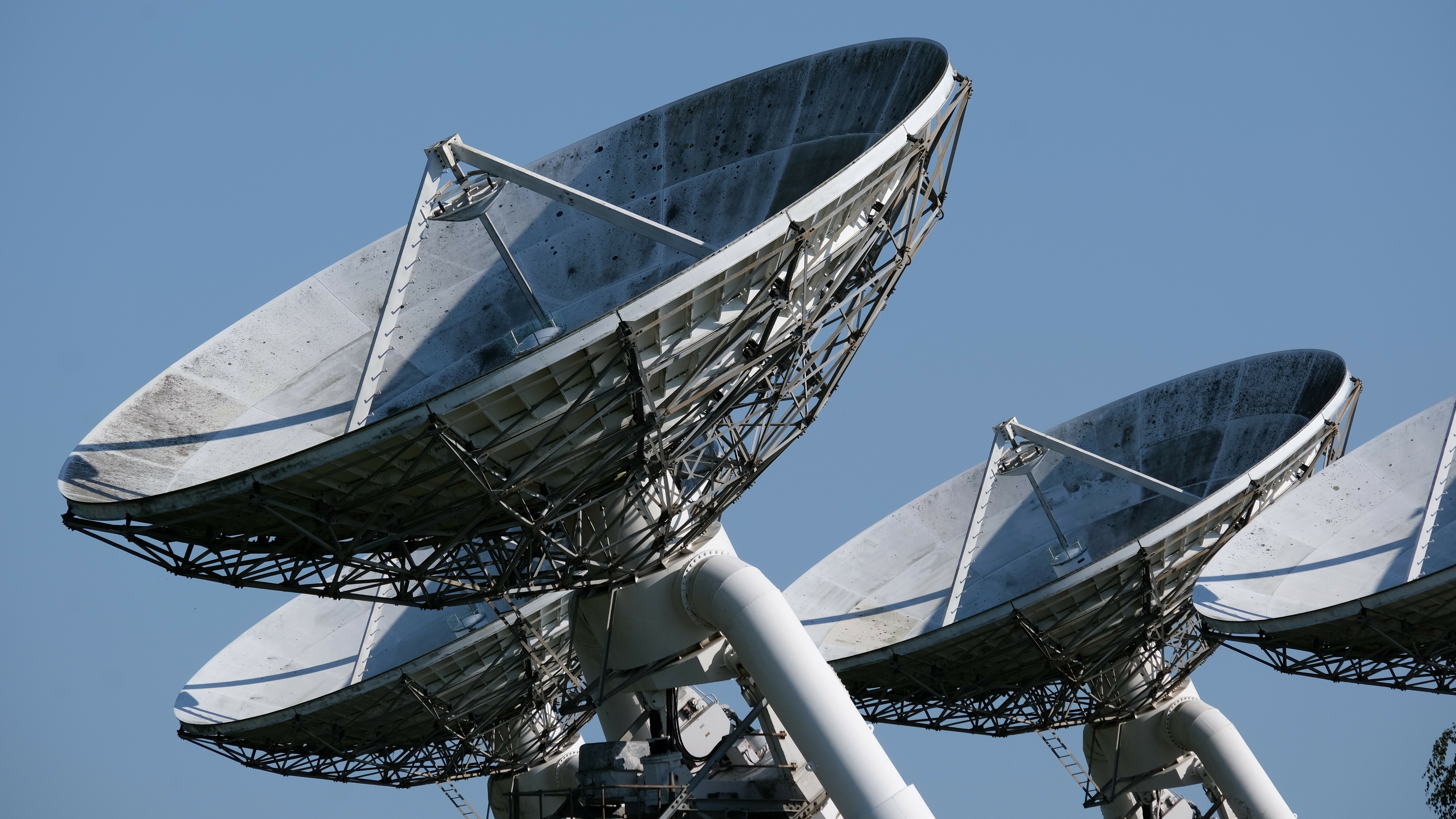 Multiple radio telescopes against a clear blue sky HD Wallpaper