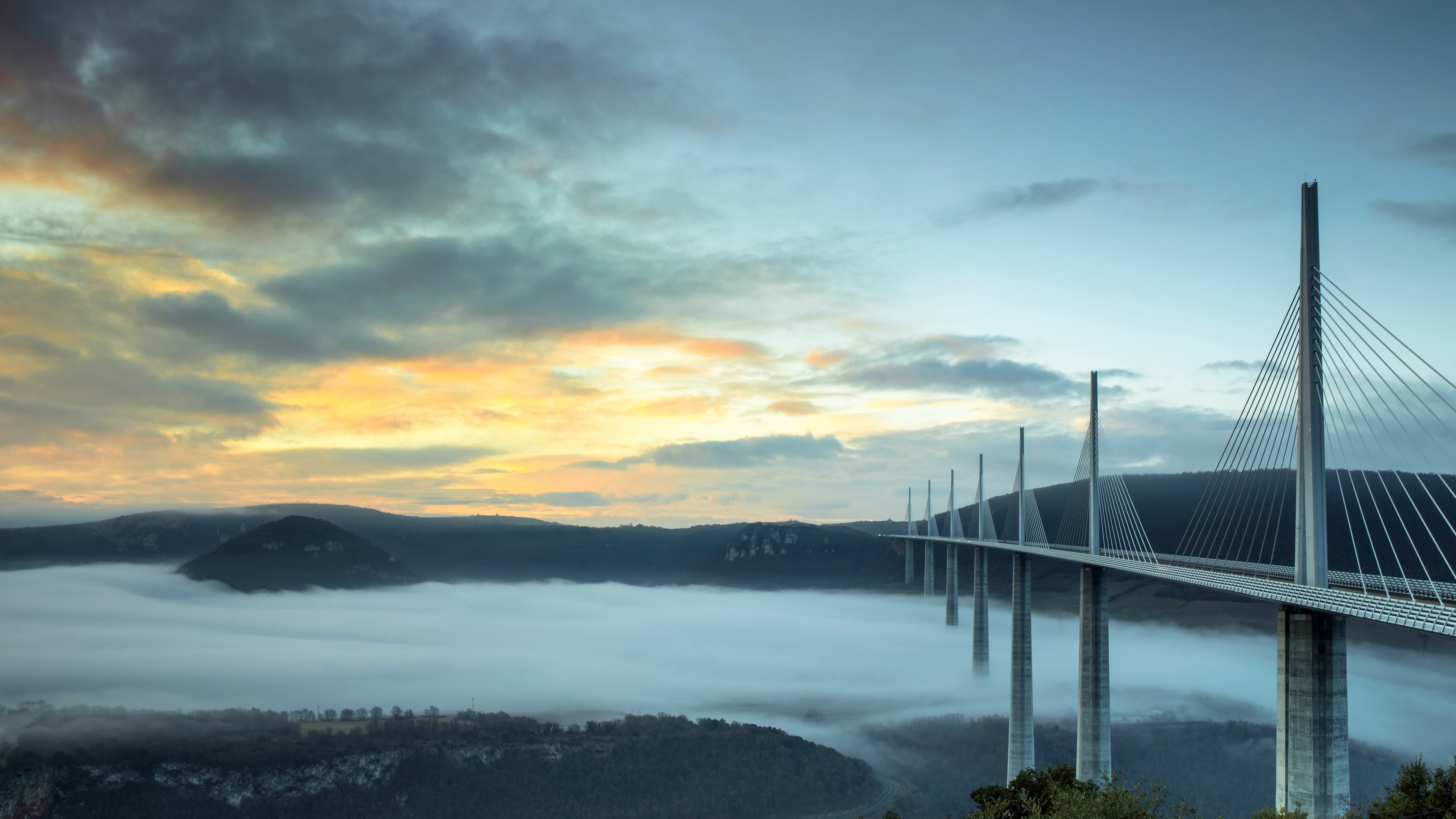 Millau Viaduct at sunset with fog HD Wallpaper
