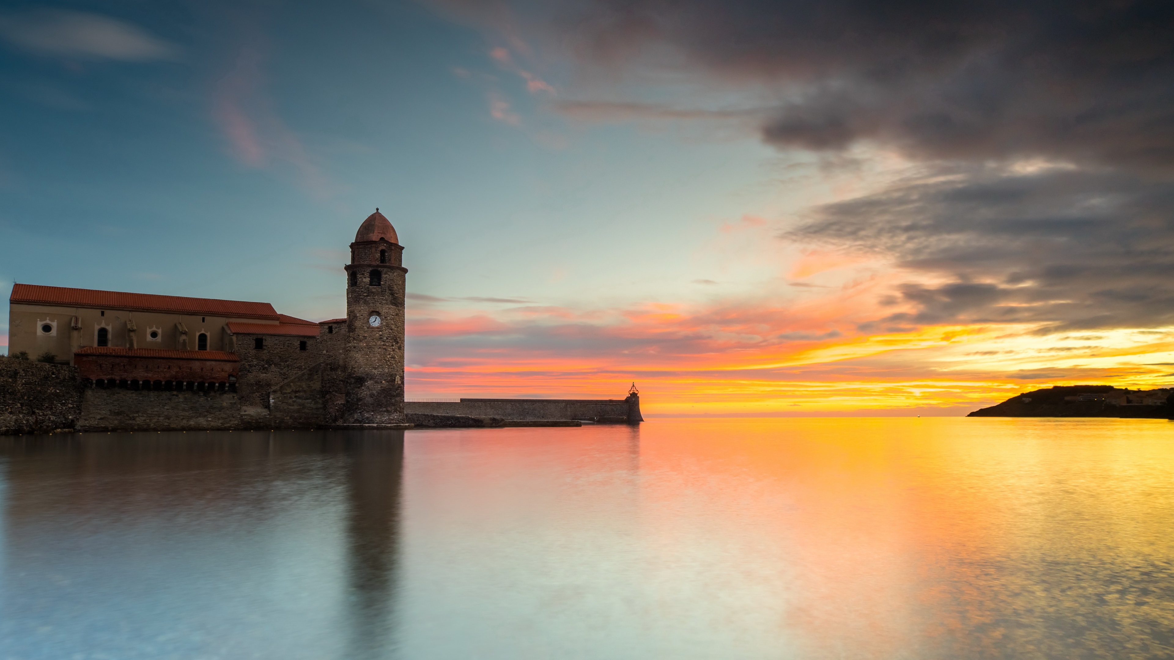 Church and lighthouse by the sea at sunset HD Wallpaper