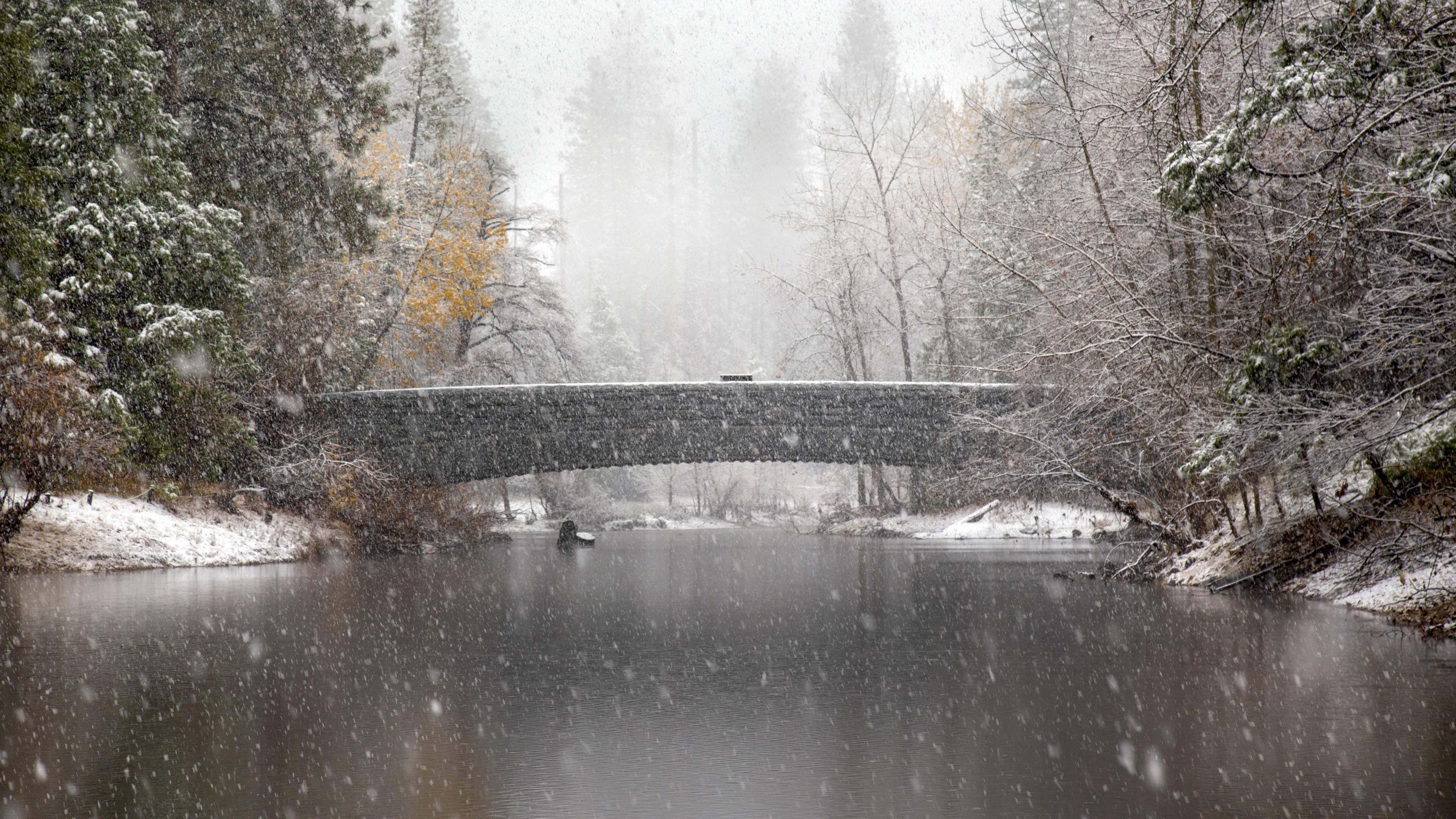 Stone bridge over water during snowfall in Yosemite HD Wallpaper