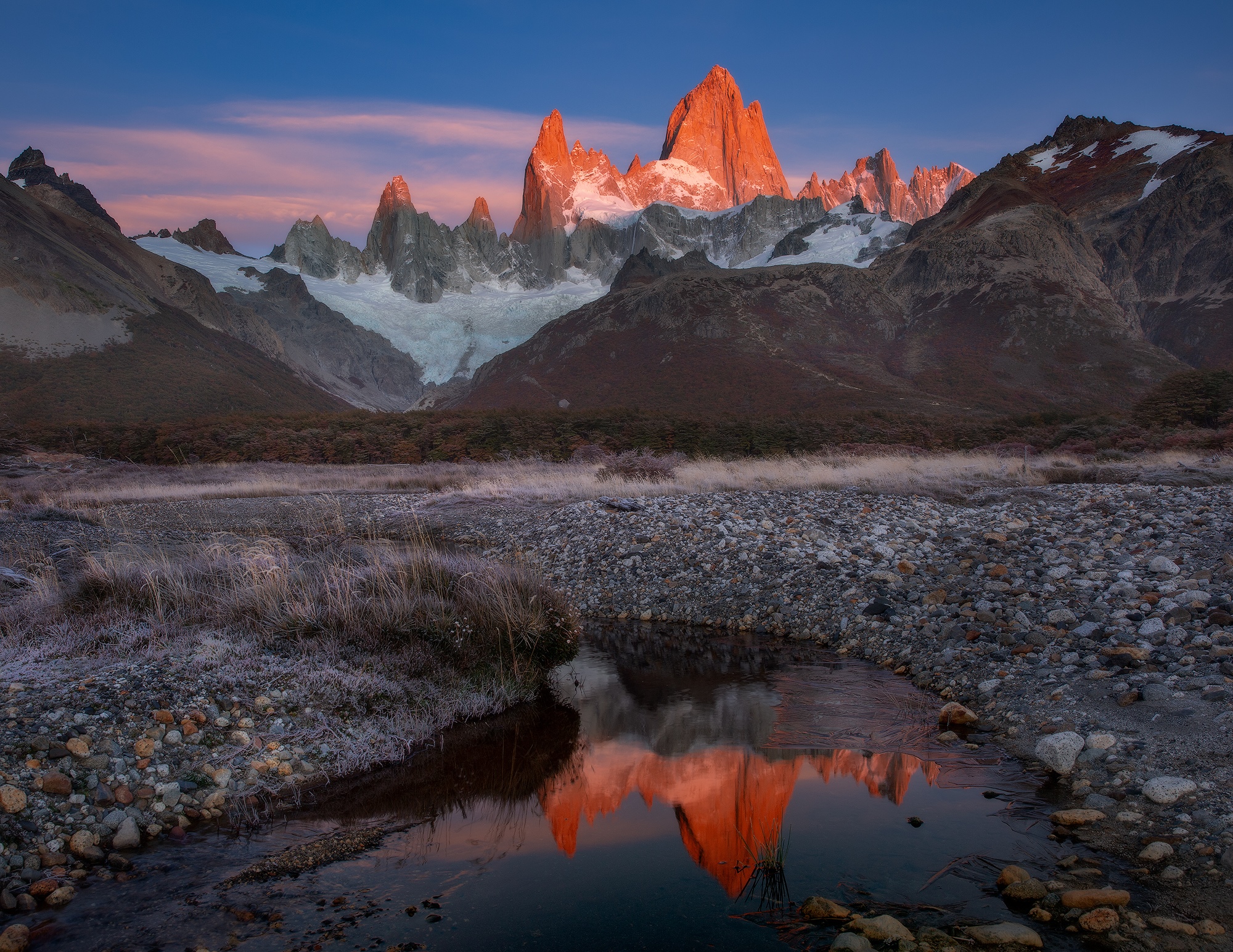Fitz Roy mountain range reflecting in a stream at sunset HD Wallpaper