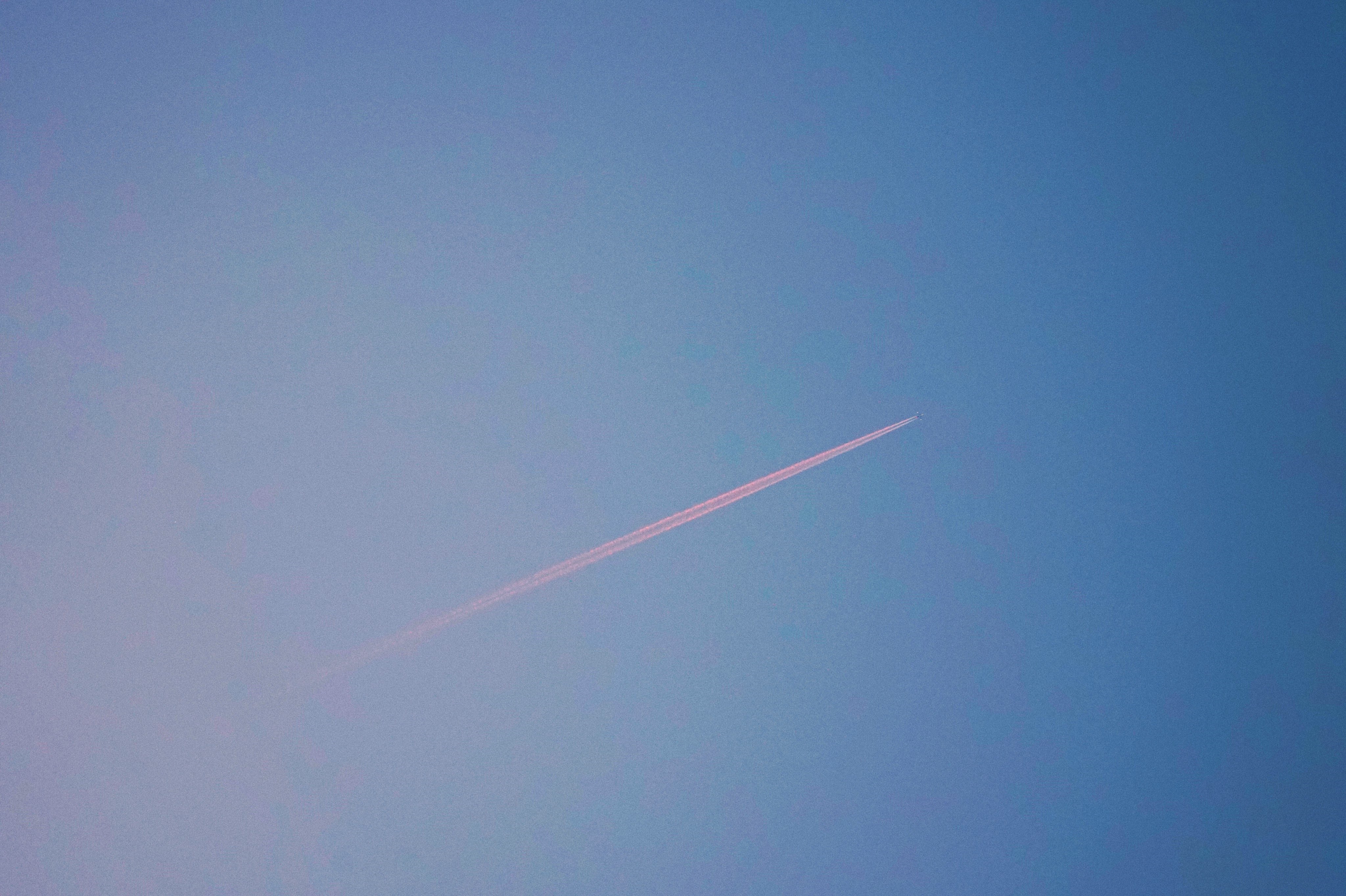 4K airplane contrail in blue sky HD Wallpaper
