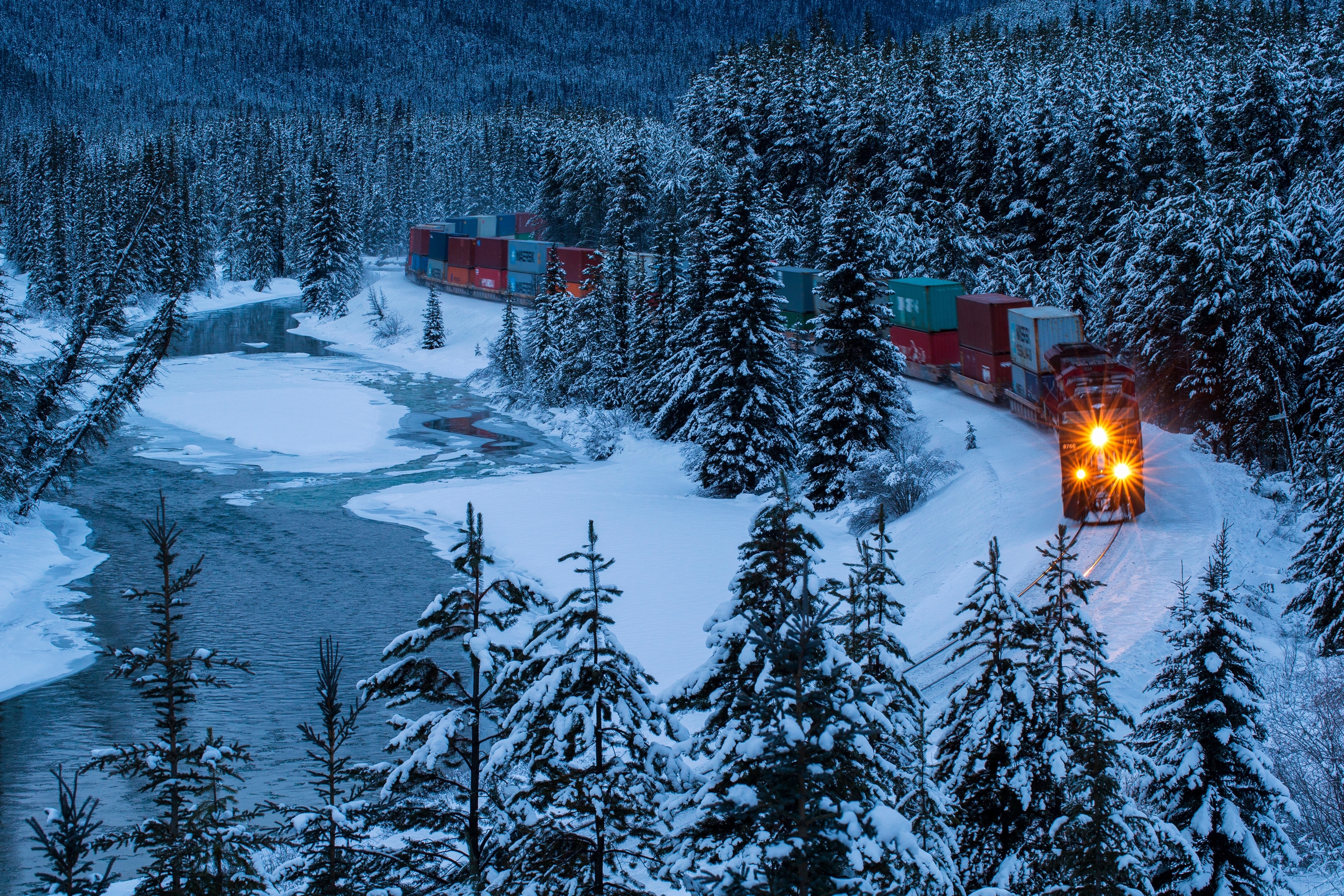 4K train in snowy forest by river HD Wallpaper