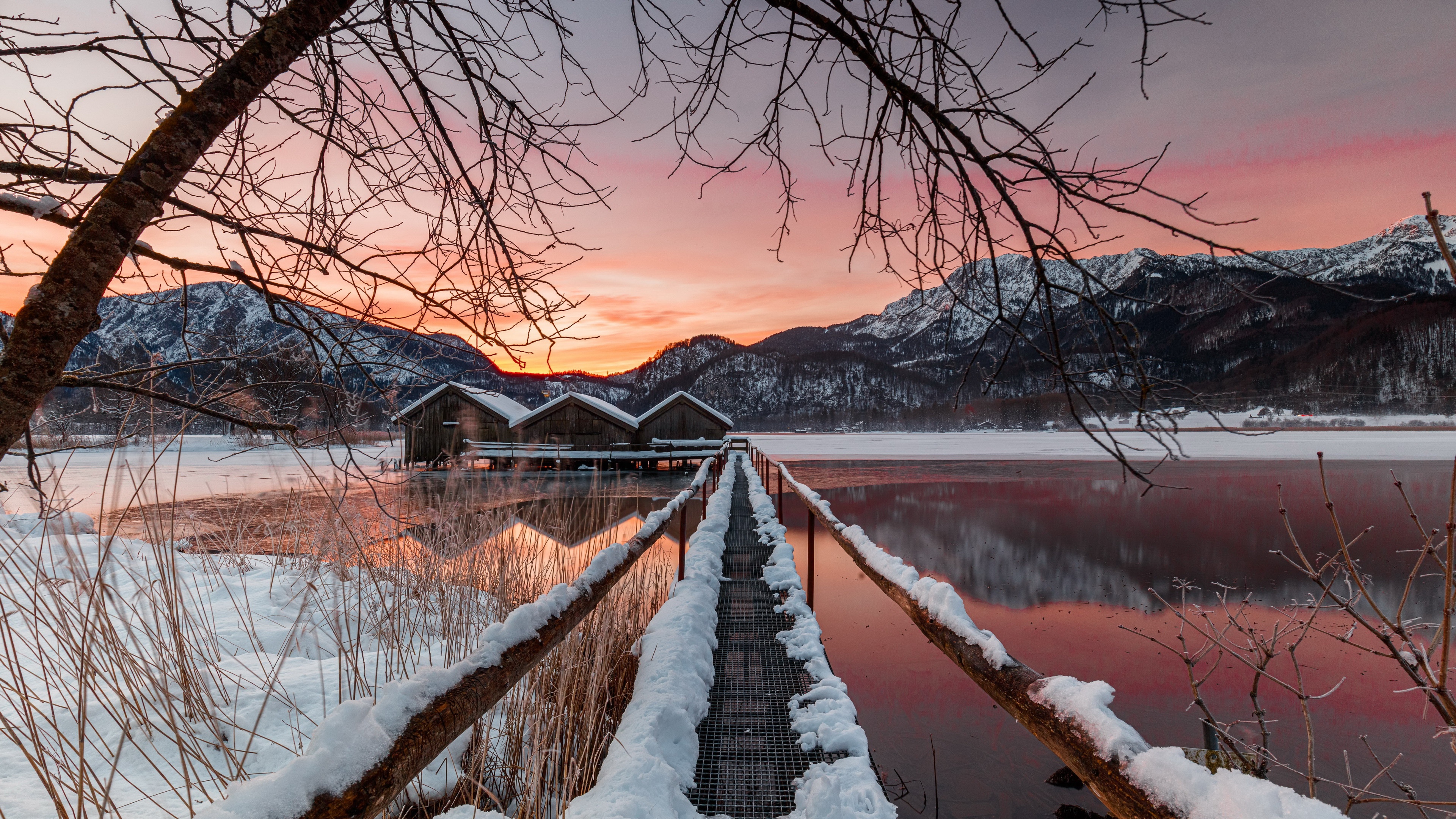Winter sunset over a frozen lake with boathouses HD Wallpaper