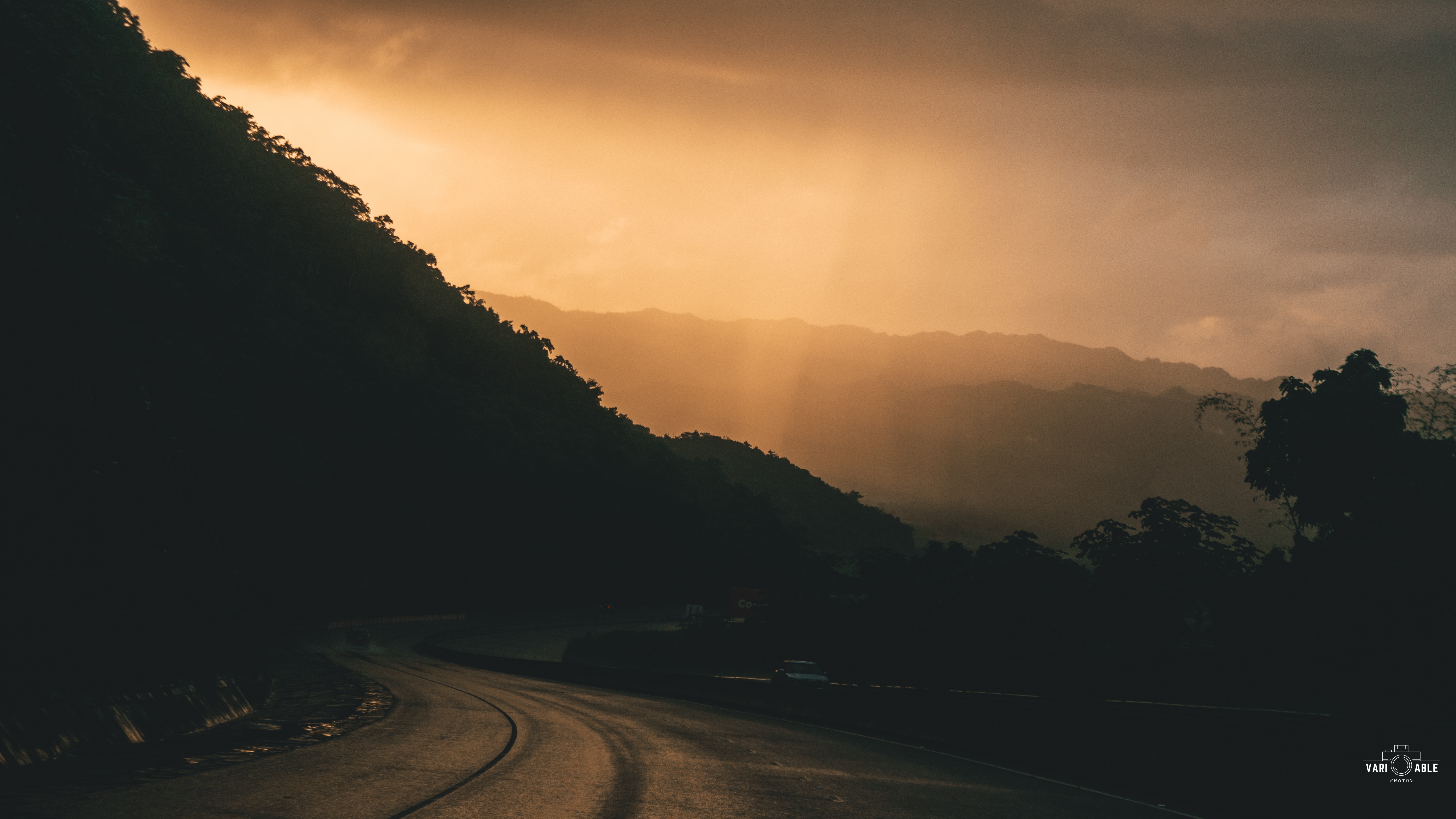 Road through mountains during sunset with sun rays HD Wallpaper