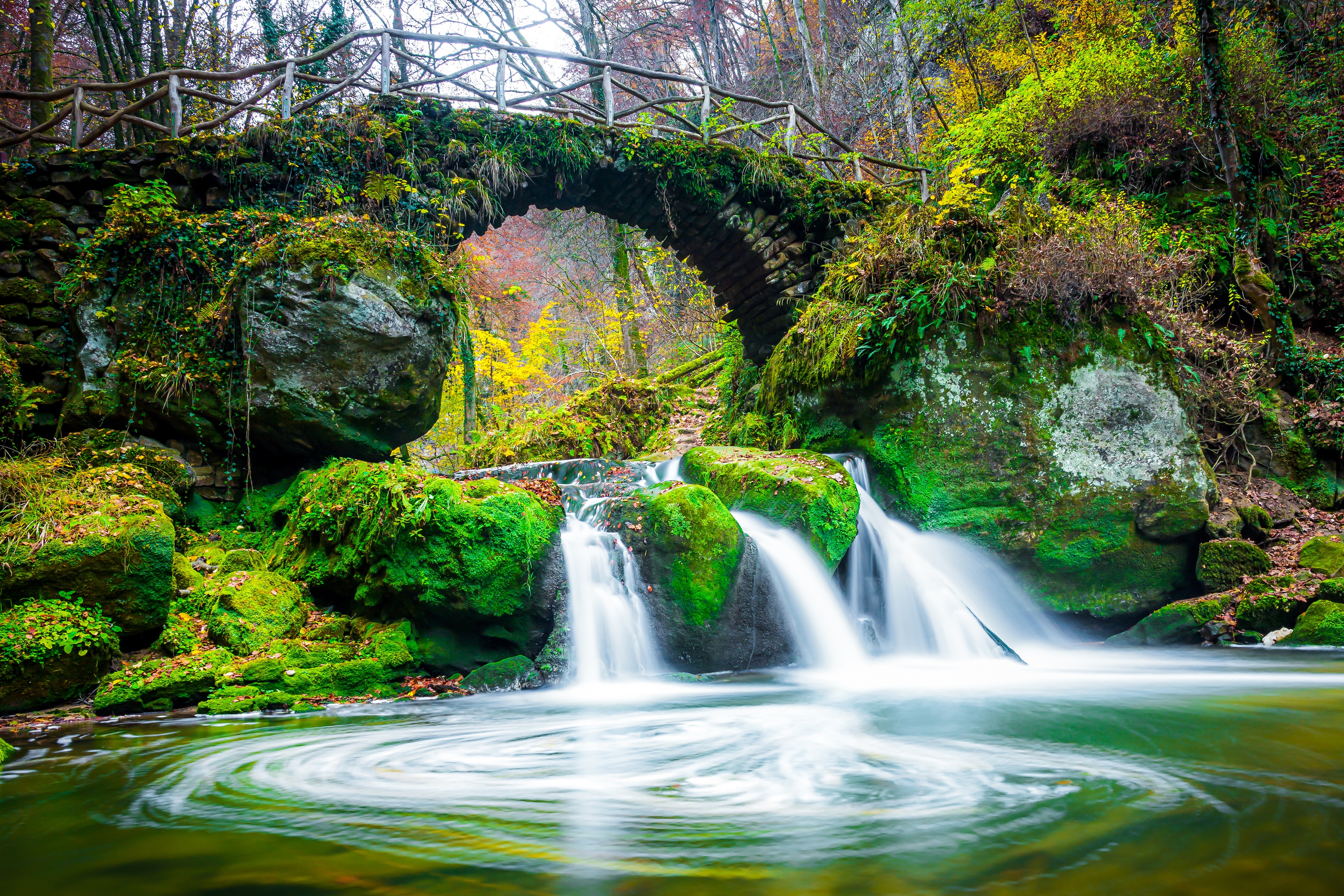 Moss-covered stone bridge over a waterfall in Luxembourg HD Wallpaper