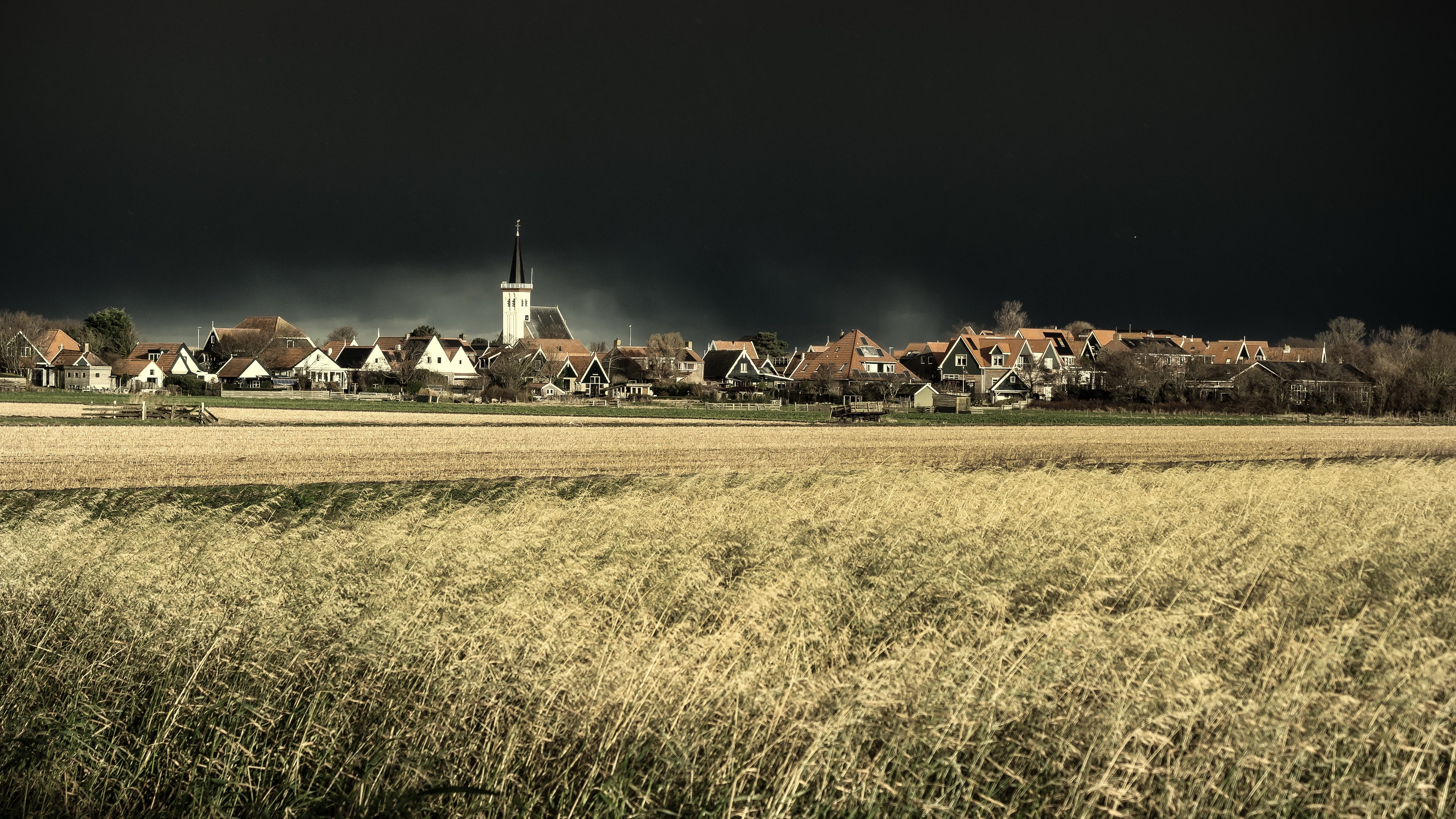 Village in the Netherlands with a field and dark sky HD Wallpaper