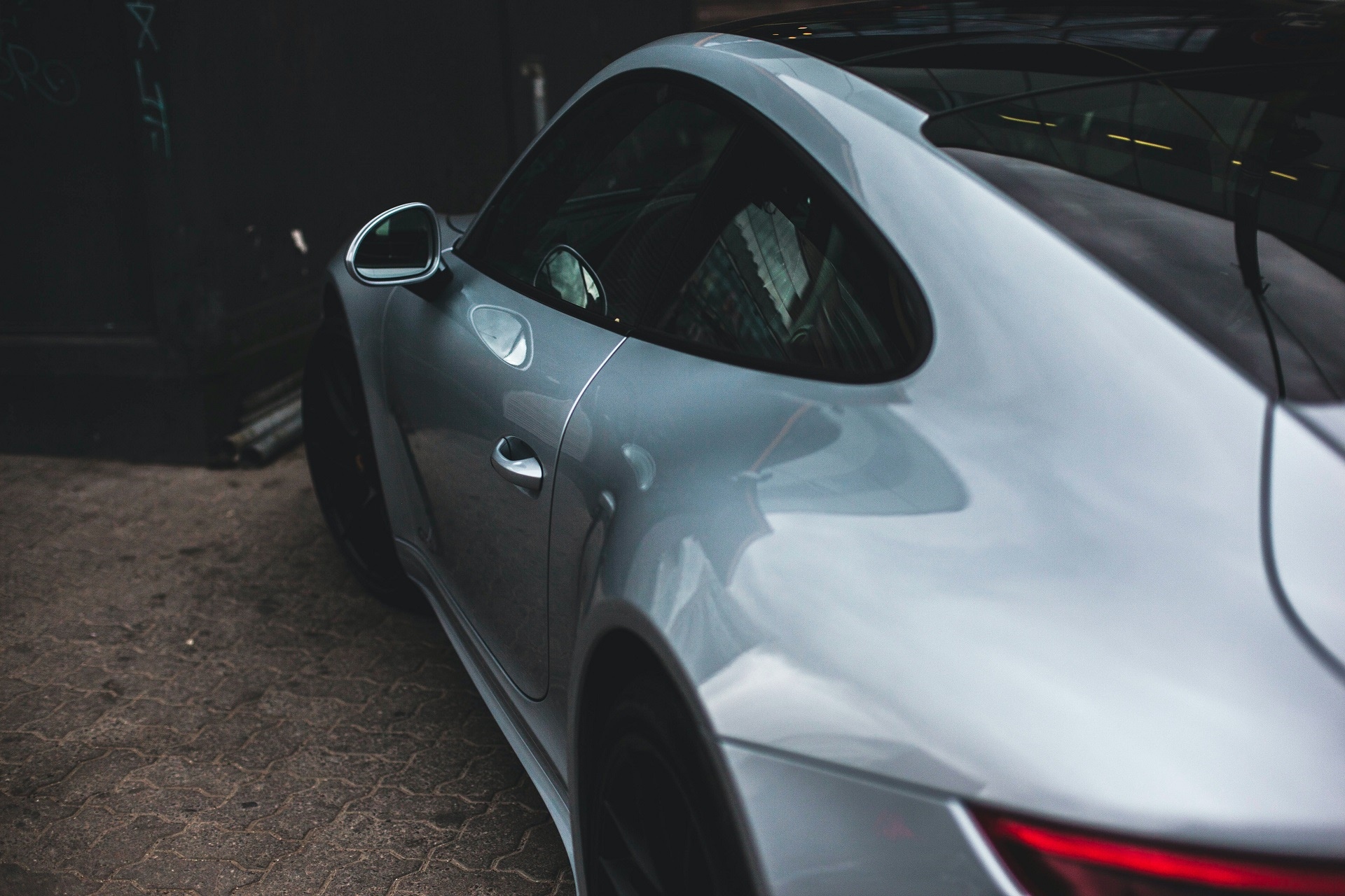 Silver Porsche 911 parked on cobblestone HD Wallpaper