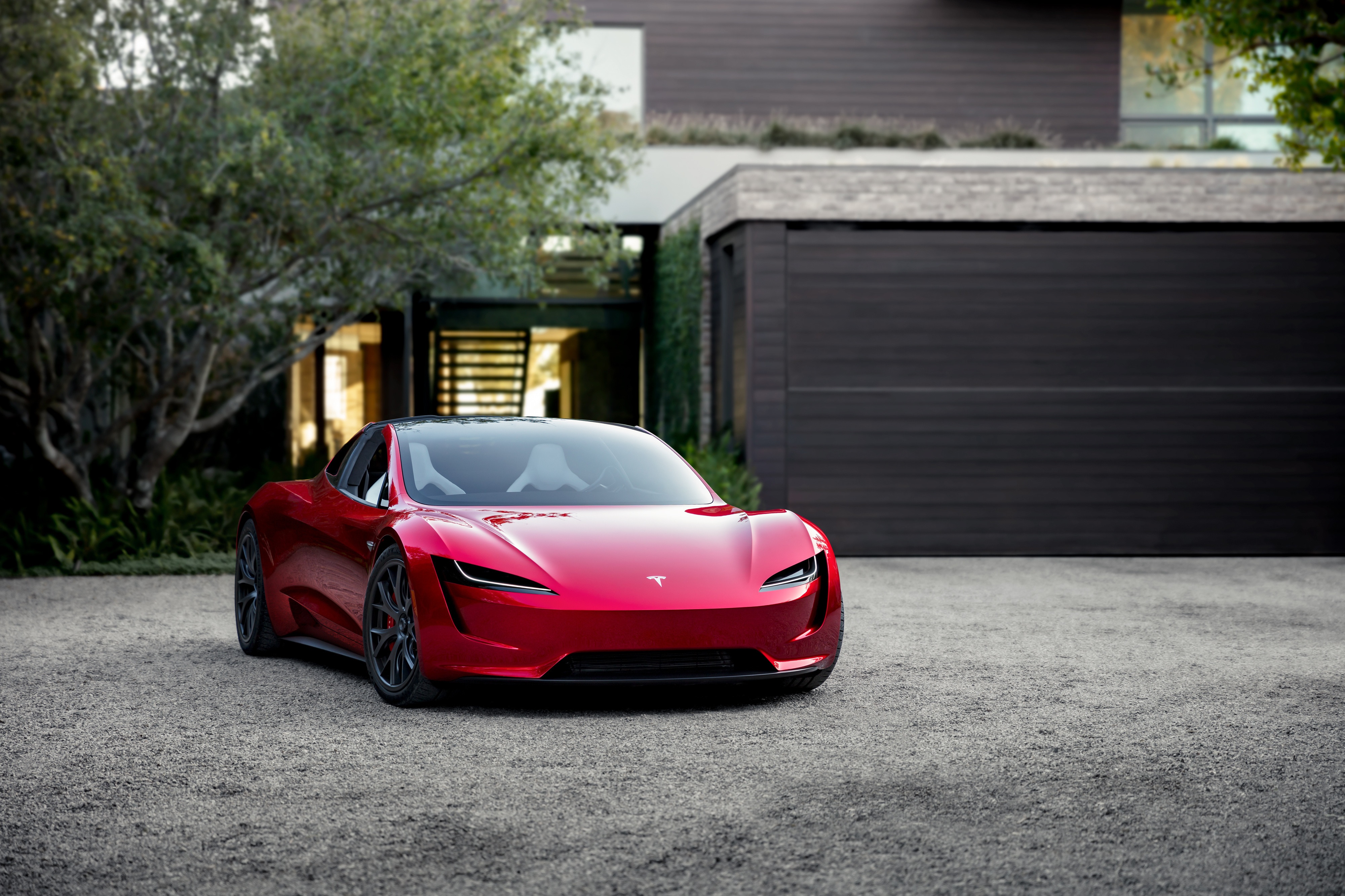 Red Tesla Roadster parked in front of a modern house HD Wallpaper