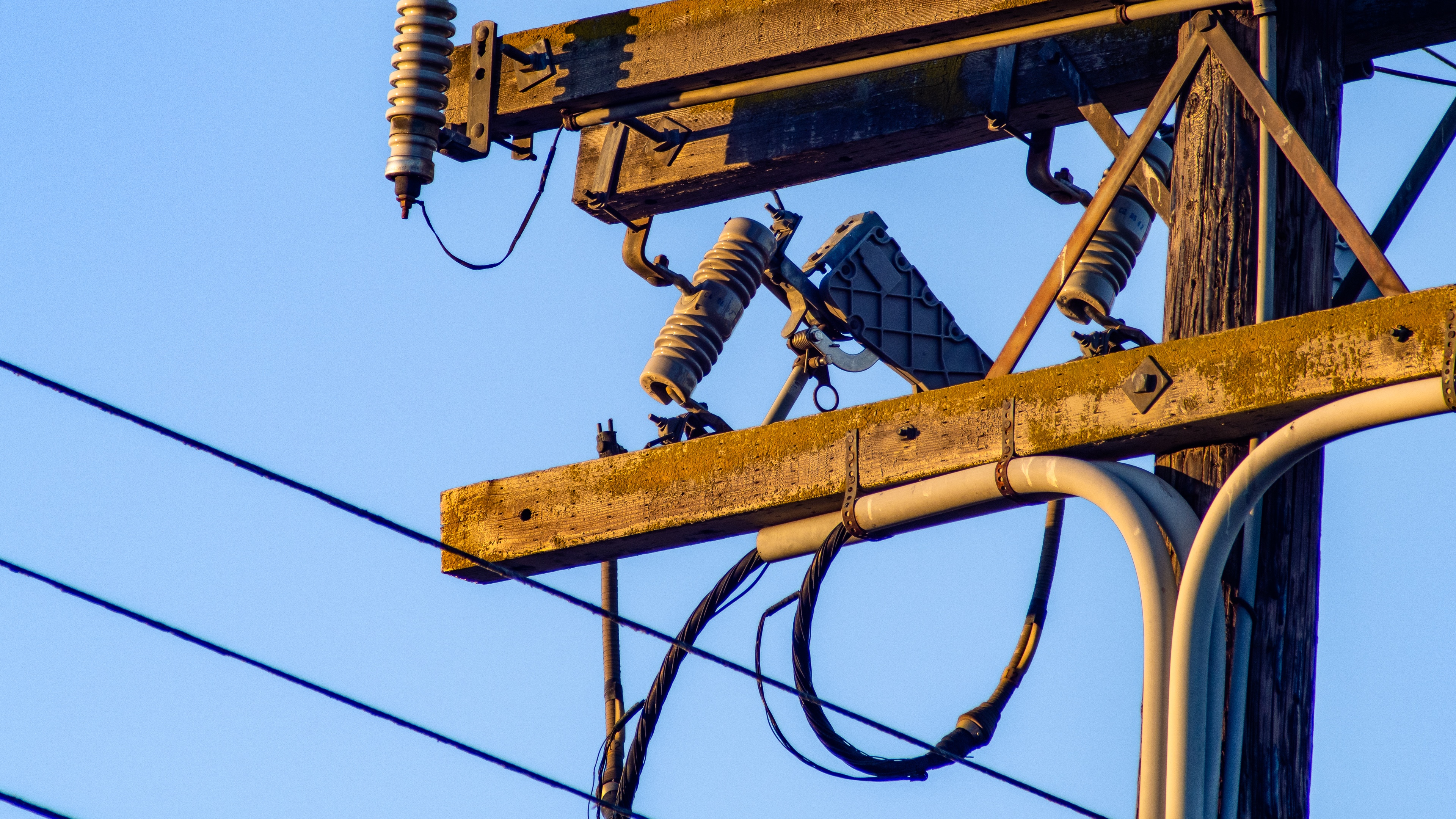 Power lines on a utility pole against clear sky HD Wallpaper