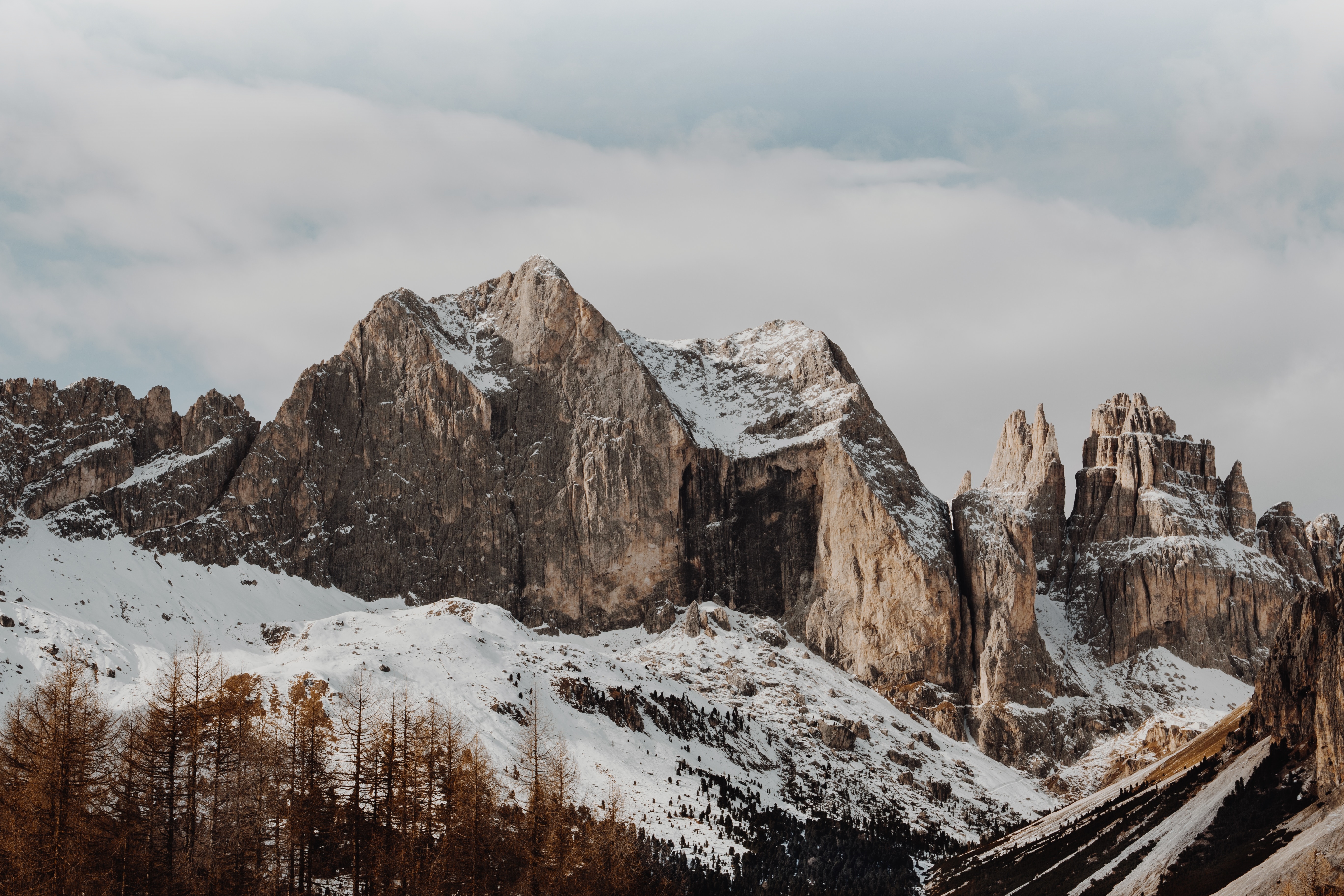 Snowy mountains and forest under cloudy sky HD Wallpaper