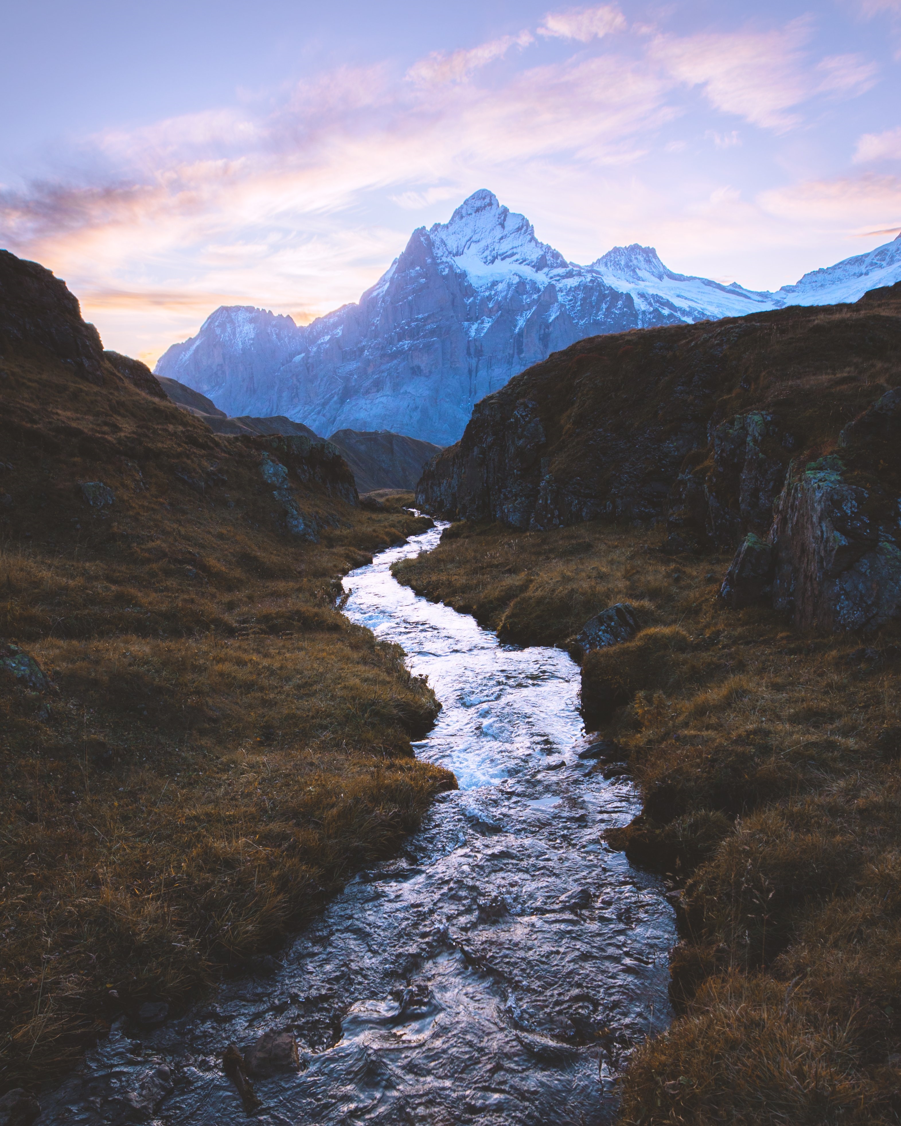 River flowing towards snowy mountains at sunset HD Phone Wallpaper