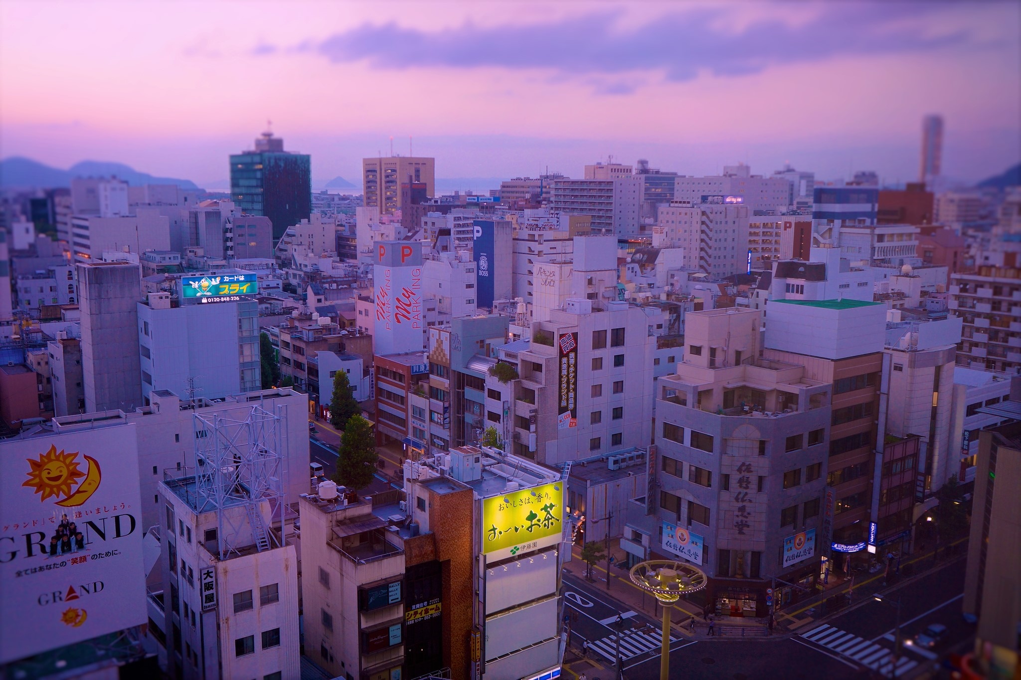 Cityscape at dusk with purple sky and buildings HD Wallpaper