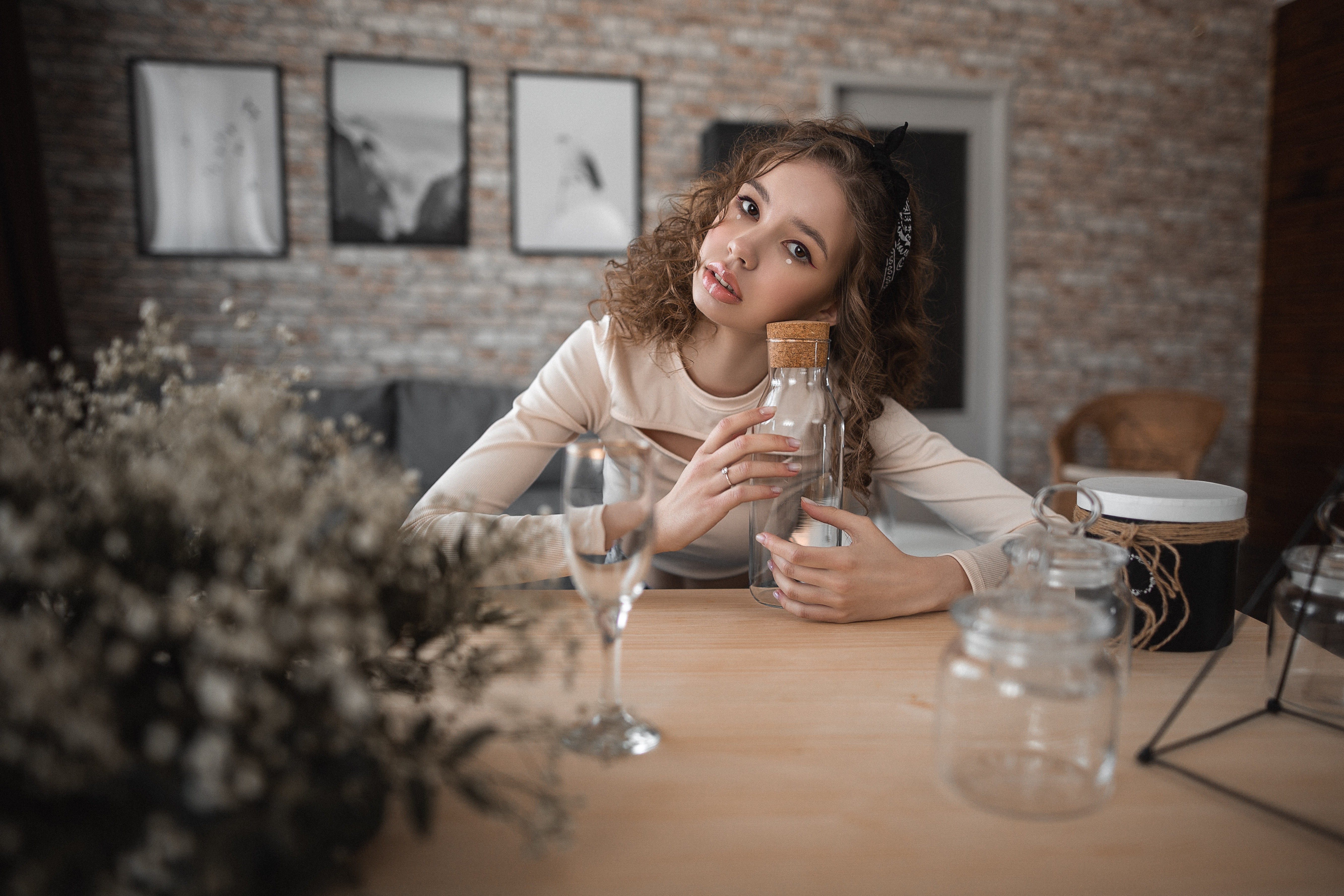 Woman with curly brunette hair holding a glass bottle HD Wallpaper