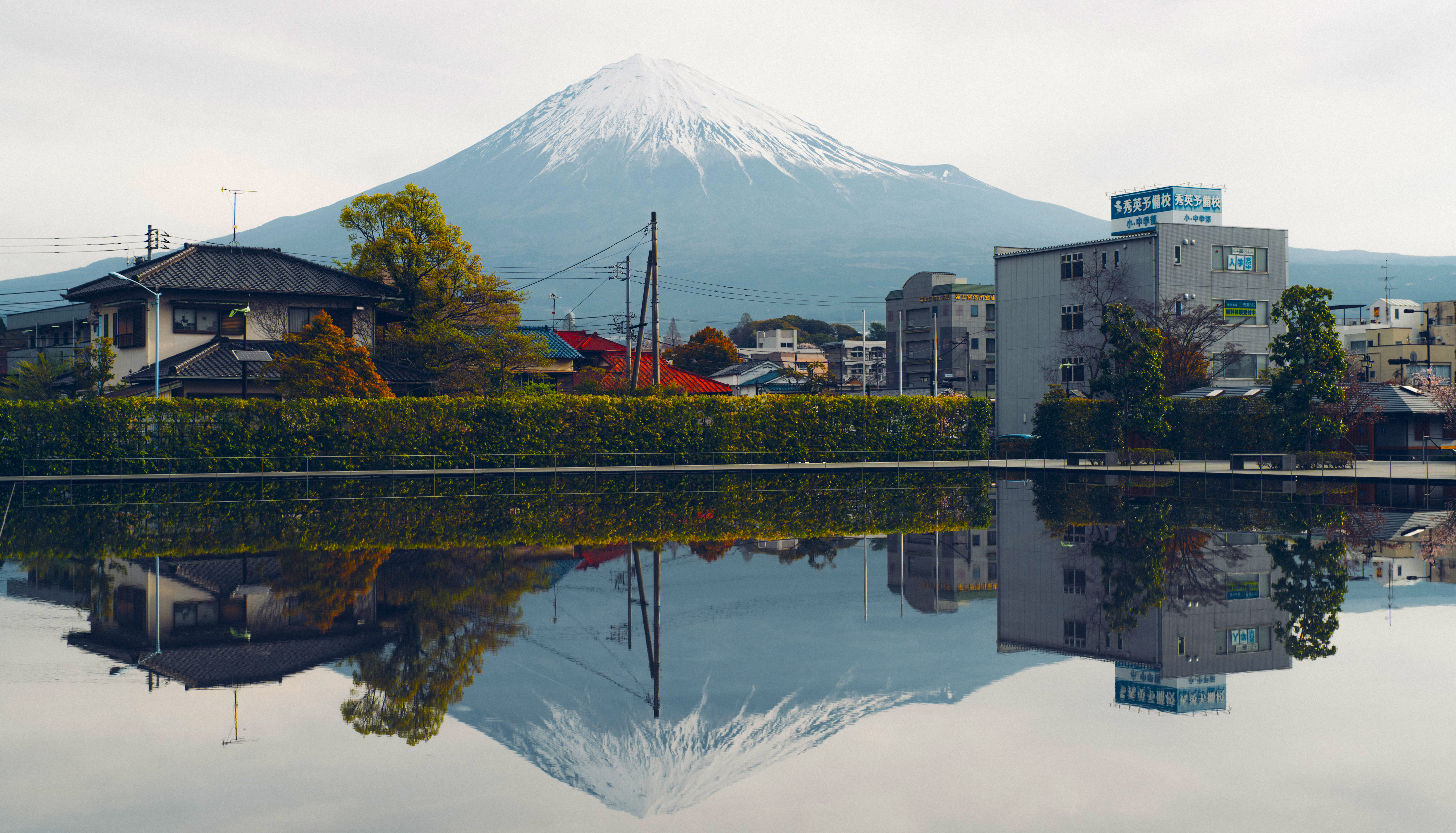 Mount Fuji reflected in water with buildings HD Wallpaper