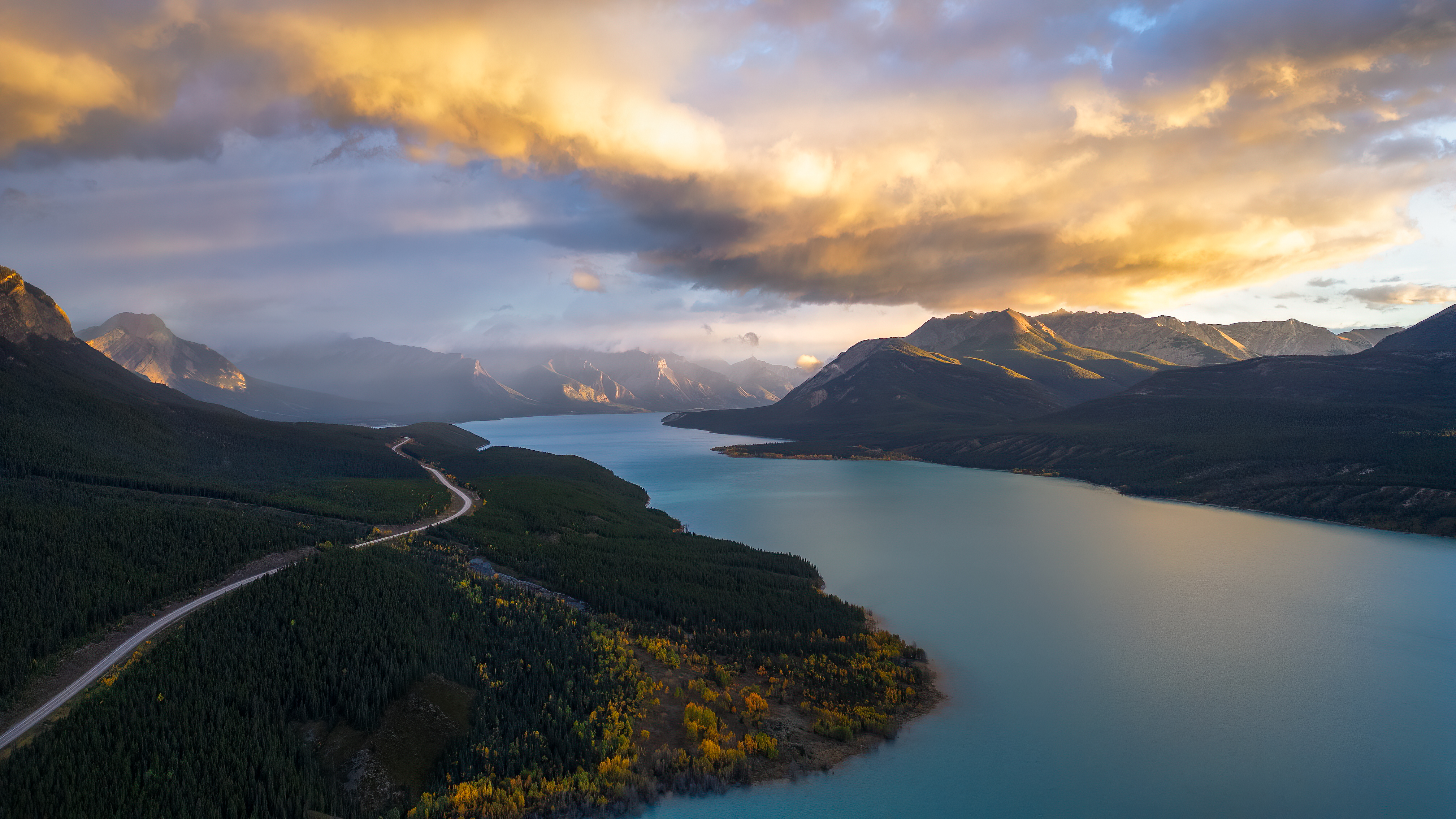 Turquoise lake surrounded by mountains and forest in Alberta, Canada HD Wallpaper