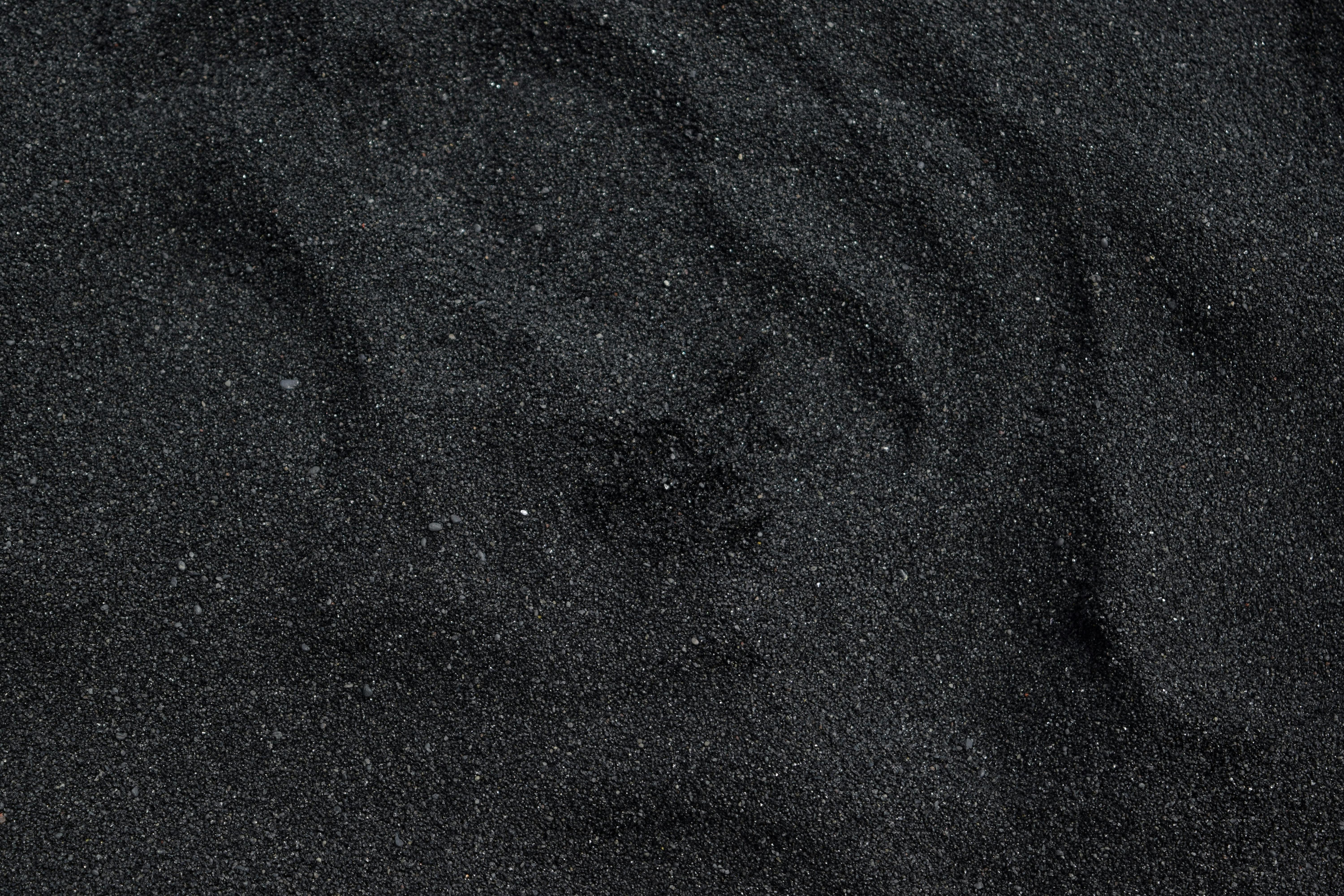 Close-up of dark black sand with ripples HD Wallpaper