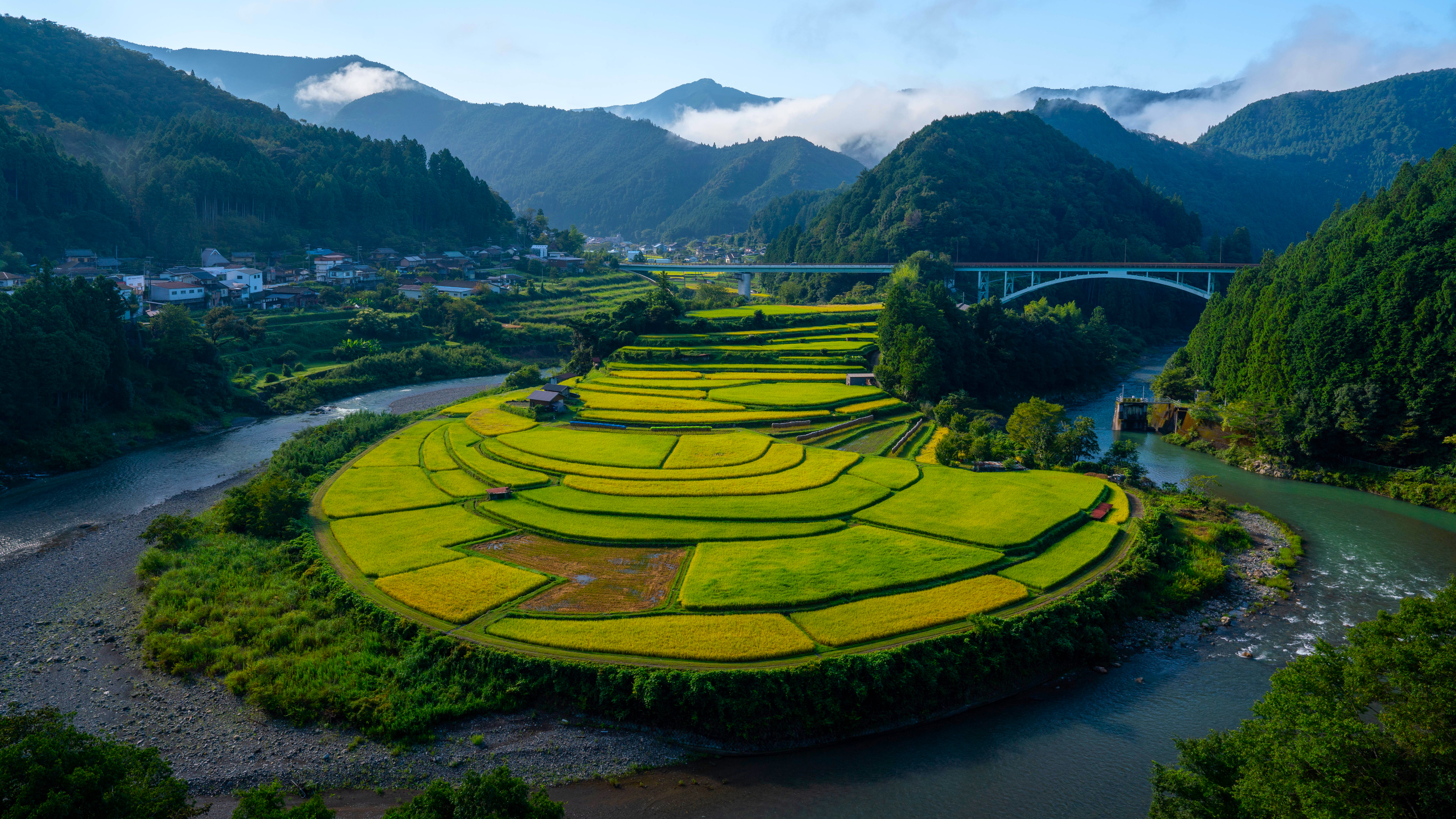 Terraced rice fields beside a winding river and mountains HD Wallpaper