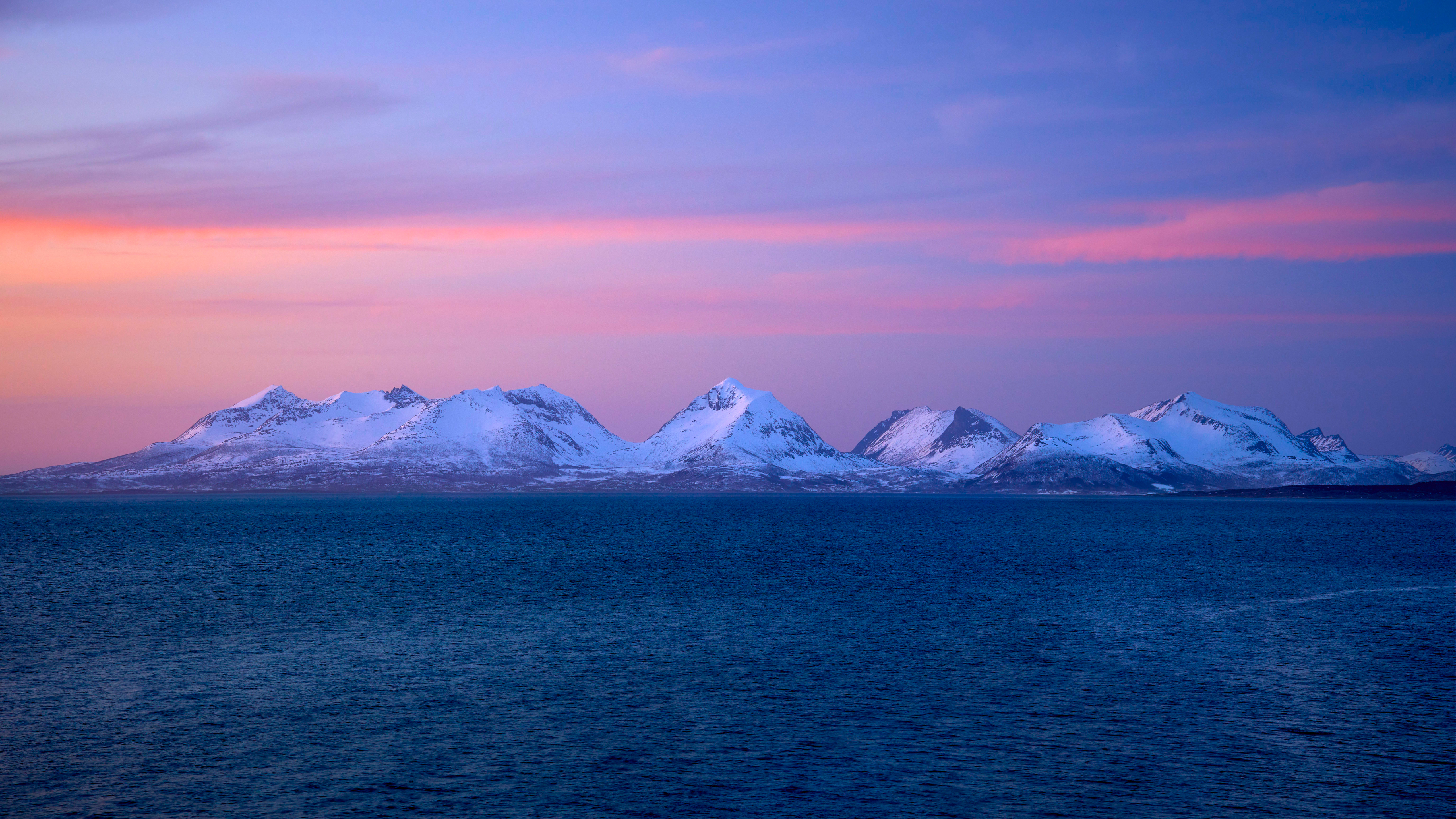 Snow-covered mountains over the sea at sunset HD Wallpaper
