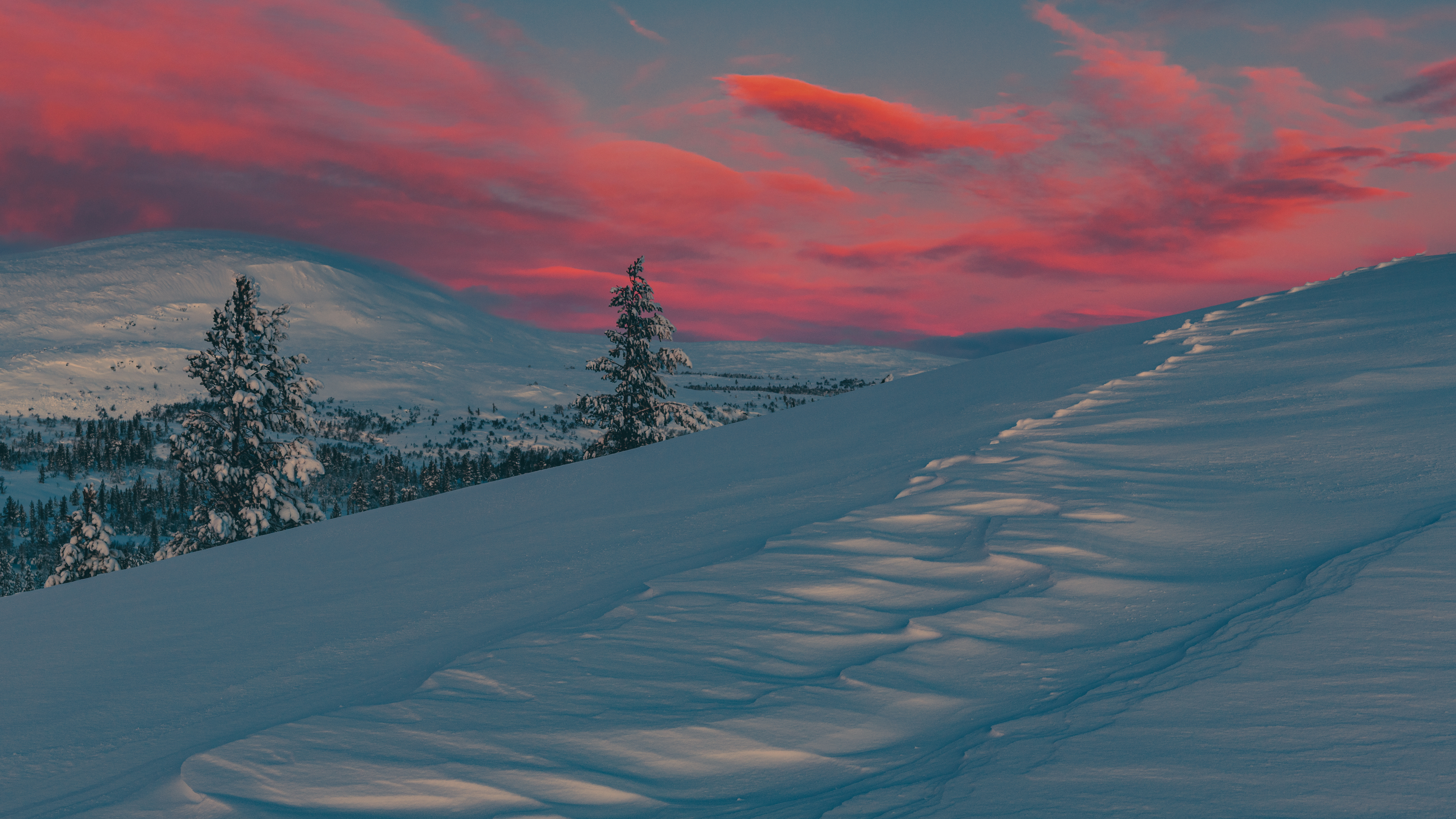 Snowy mountain landscape with sunset sky and tracks HD Wallpaper