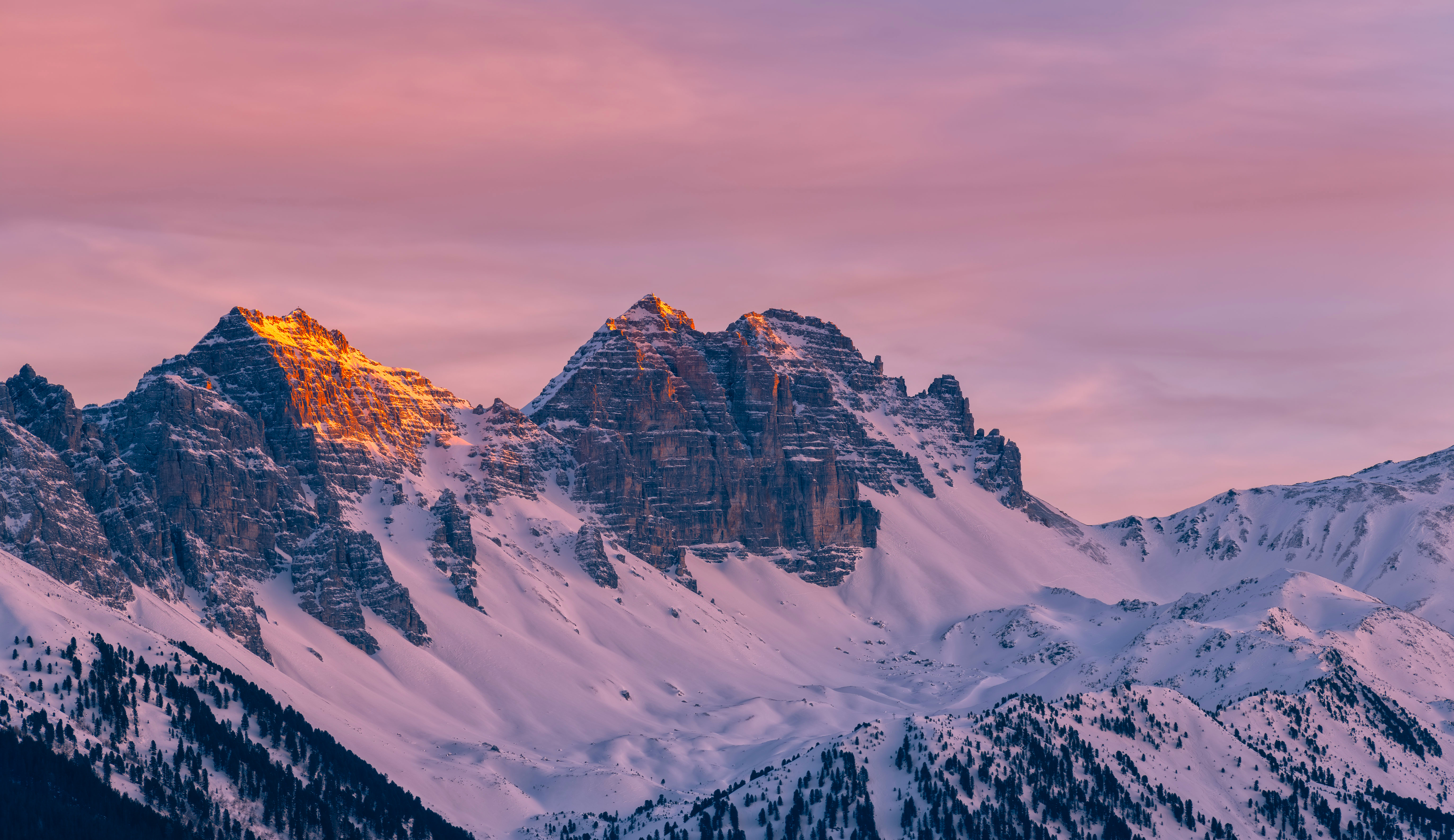 Snow-covered mountains bathed in pink and orange sunlight HD Wallpaper