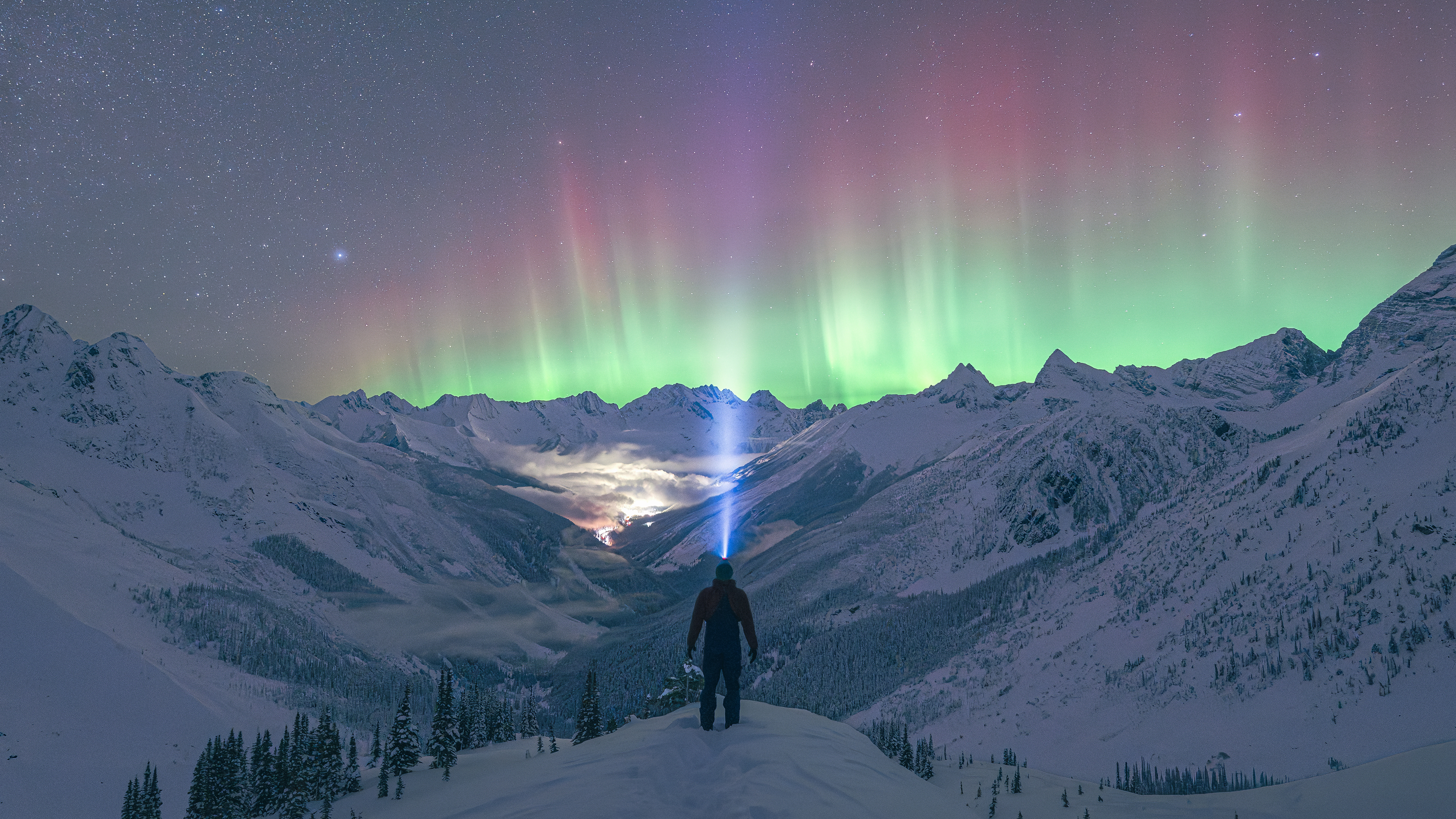 Man watches Aurora Borealis over Selkirk Mountains, Canada HD Wallpaper