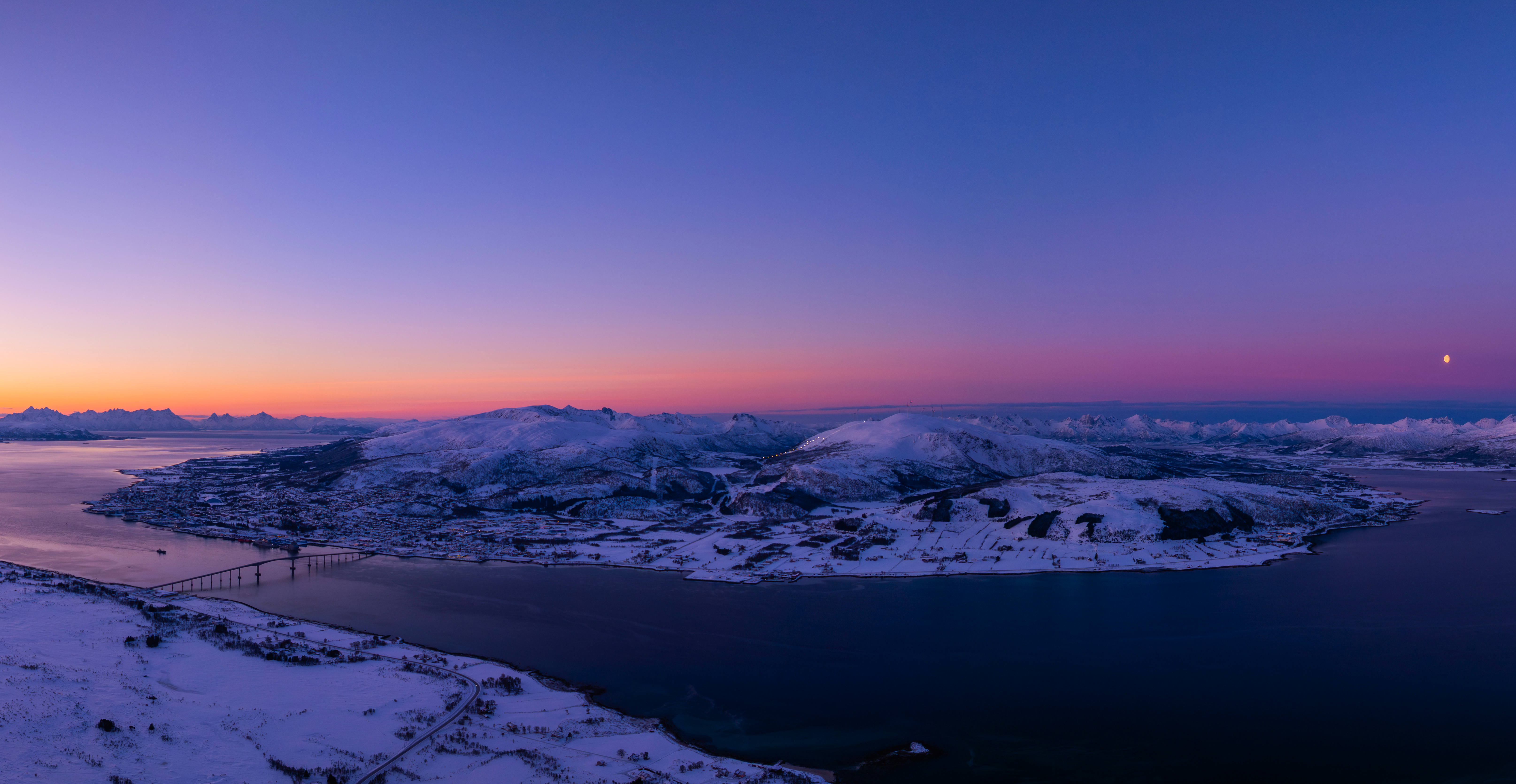 Snowy landscape with a bridge over water at sunset HD Wallpaper