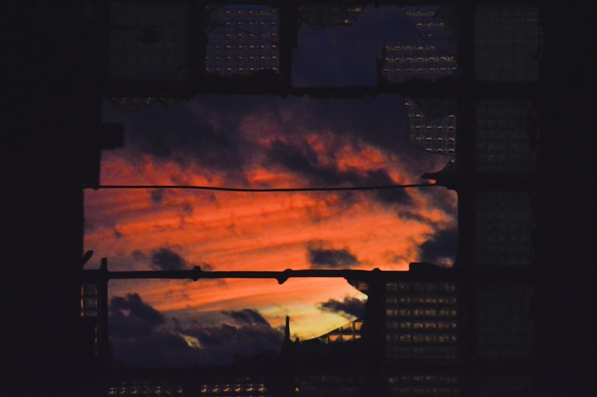 Sunset viewed through a broken window with clouds HD Wallpaper