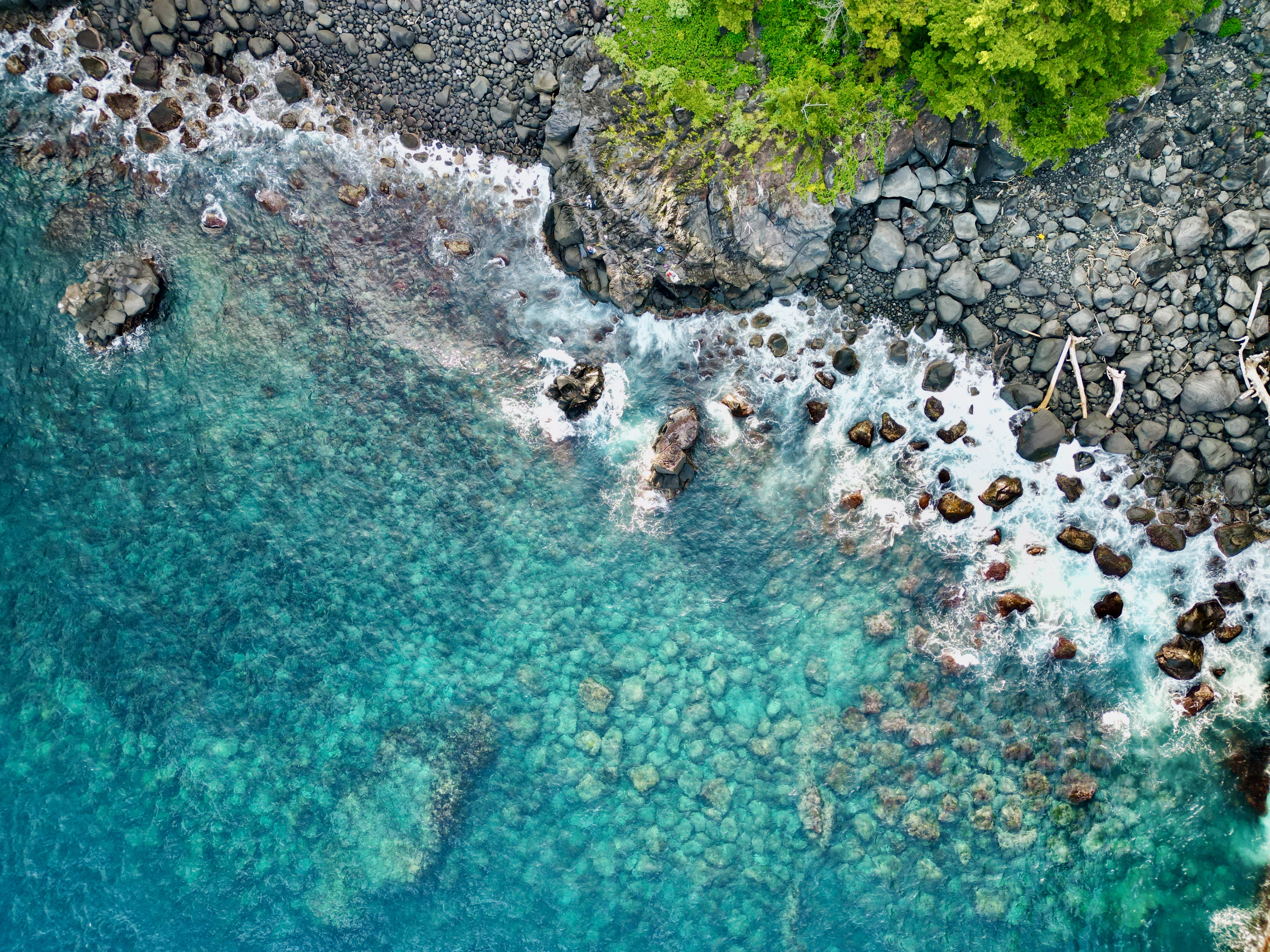 Aerial view of rocky coastline with clear turquoise water HD Wallpaper