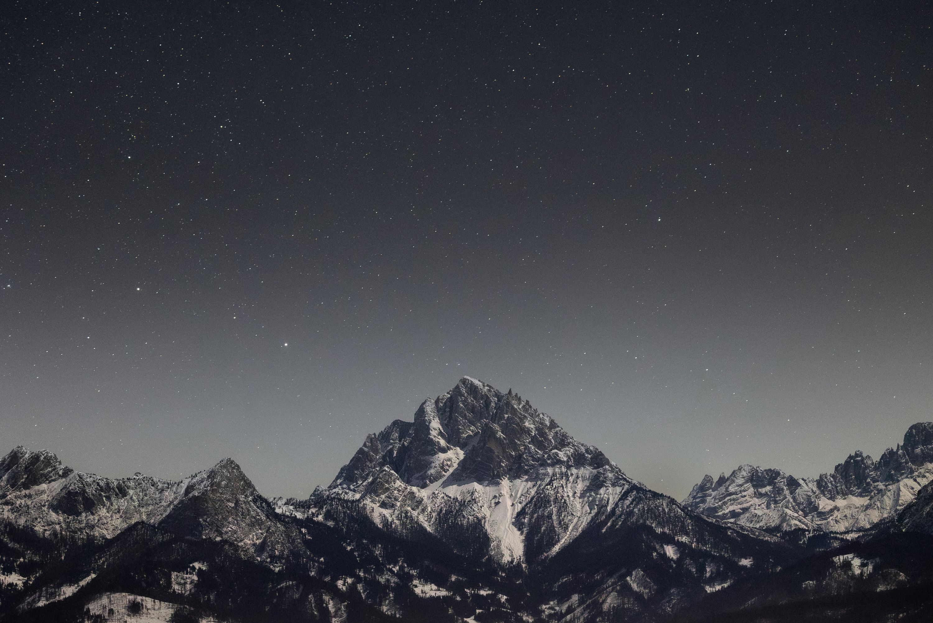 Snow-capped mountains under a starry night sky HD Wallpaper