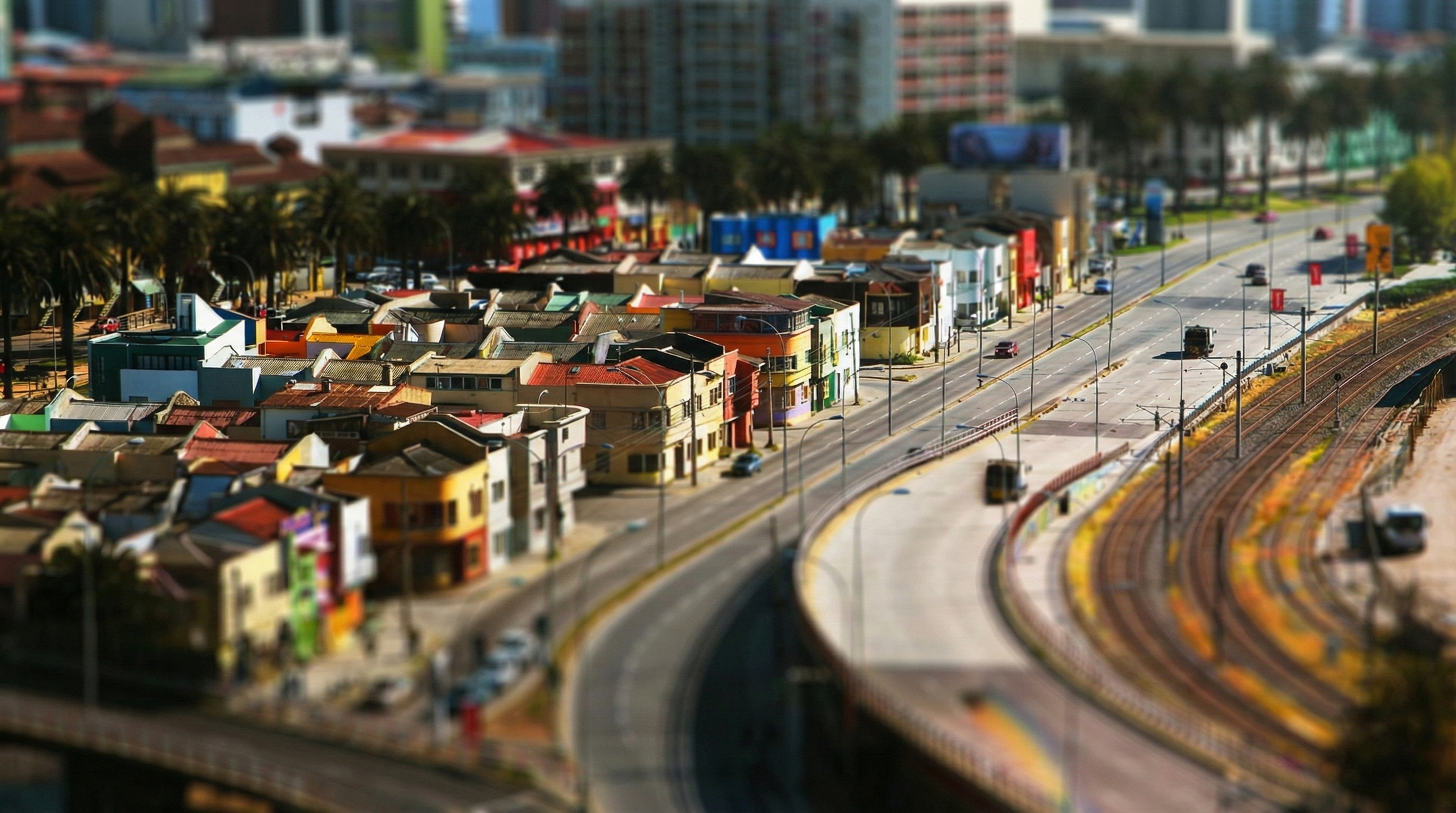 Cars on a highway next to colorful buildings in Valparaíso HD Wallpaper