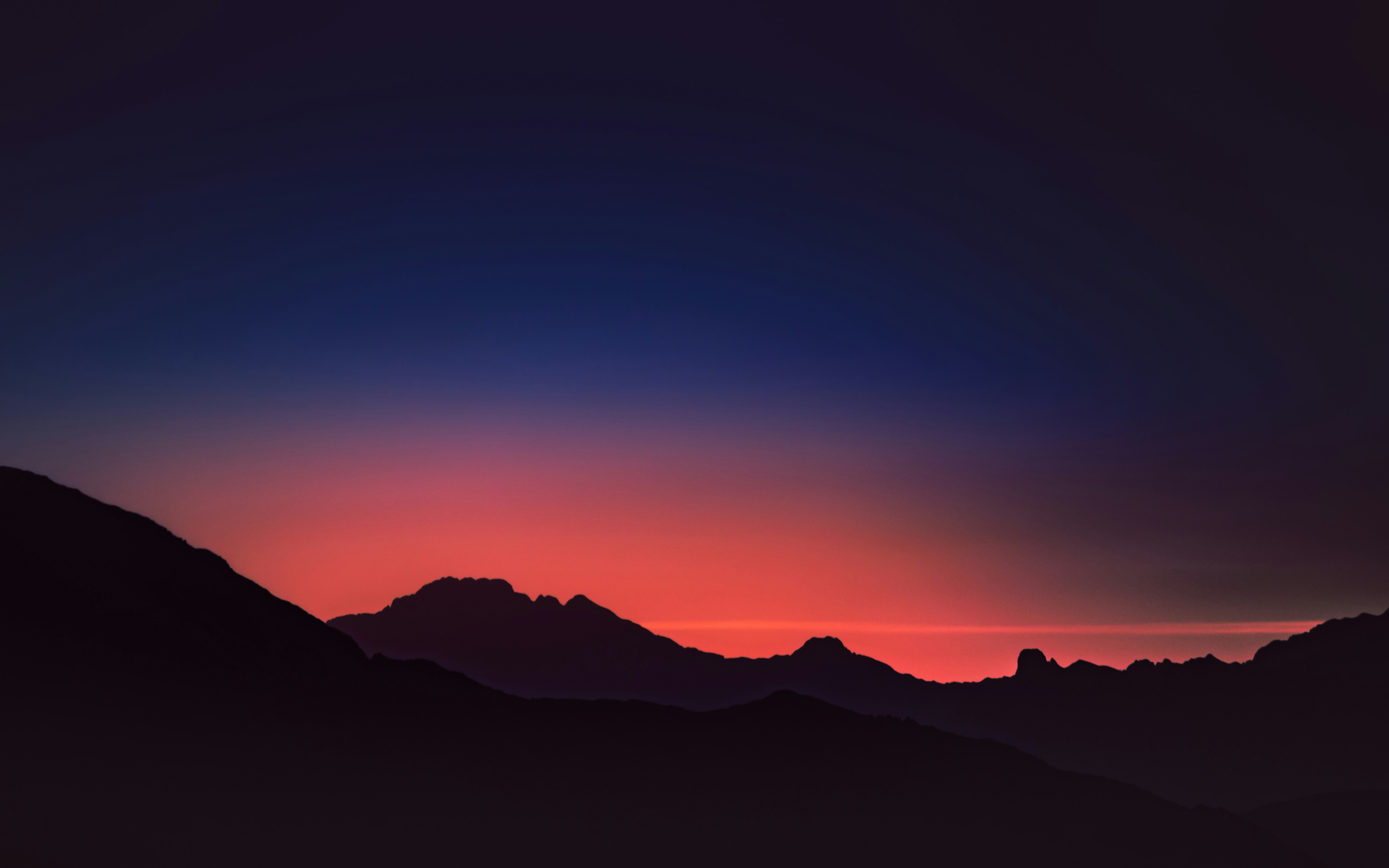 Silhouette of mountains against a colorful sunset sky HD Wallpaper